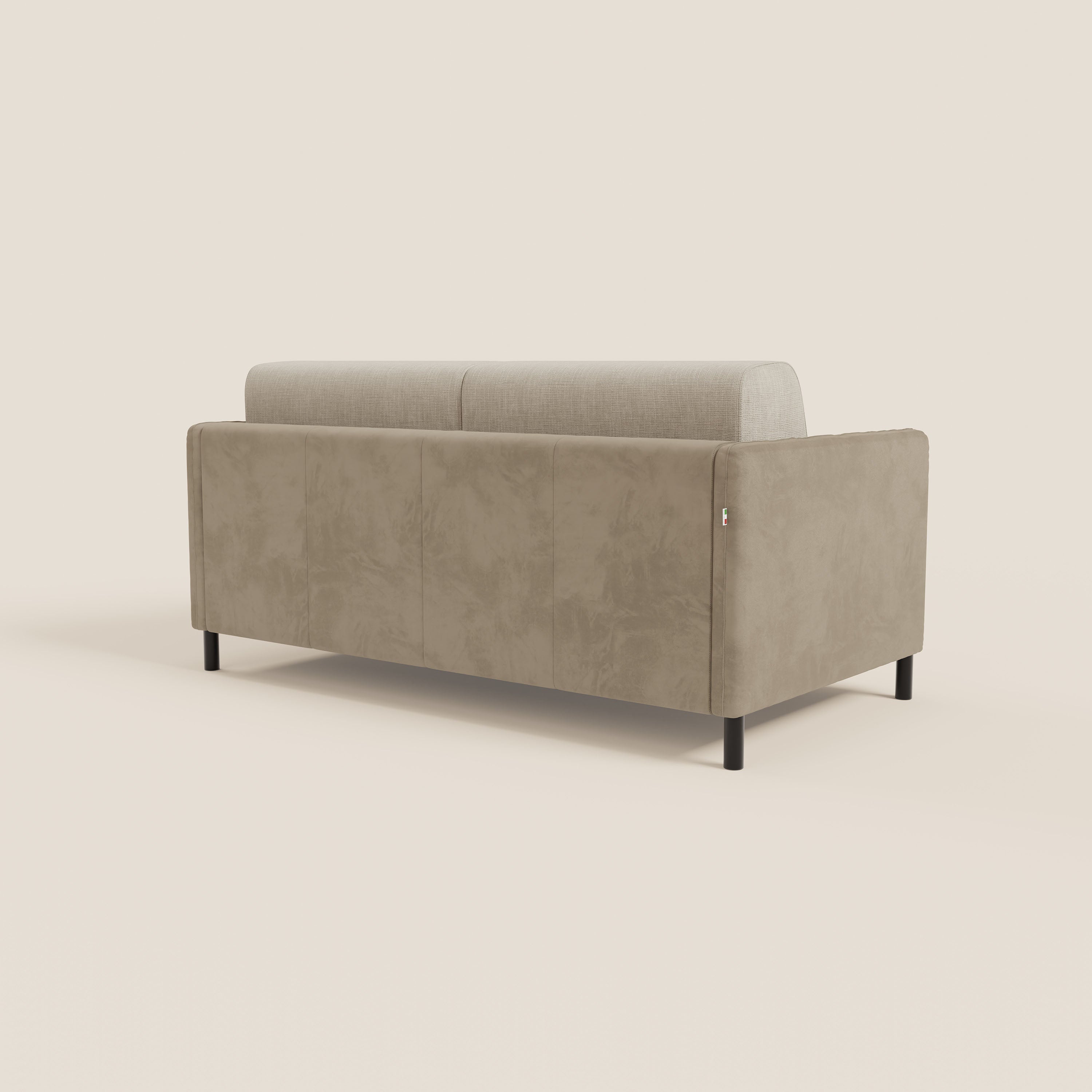 Il divano letto Narciso di Divani.Store è caratterizzato da una microfibra bicolore (T06 tortora - panna) e da eleganti cuscini impermeabili, presentati dal retro e dal lato sinistro su sottili gambe in metallo nero, su uno sfondo bianco sporco.