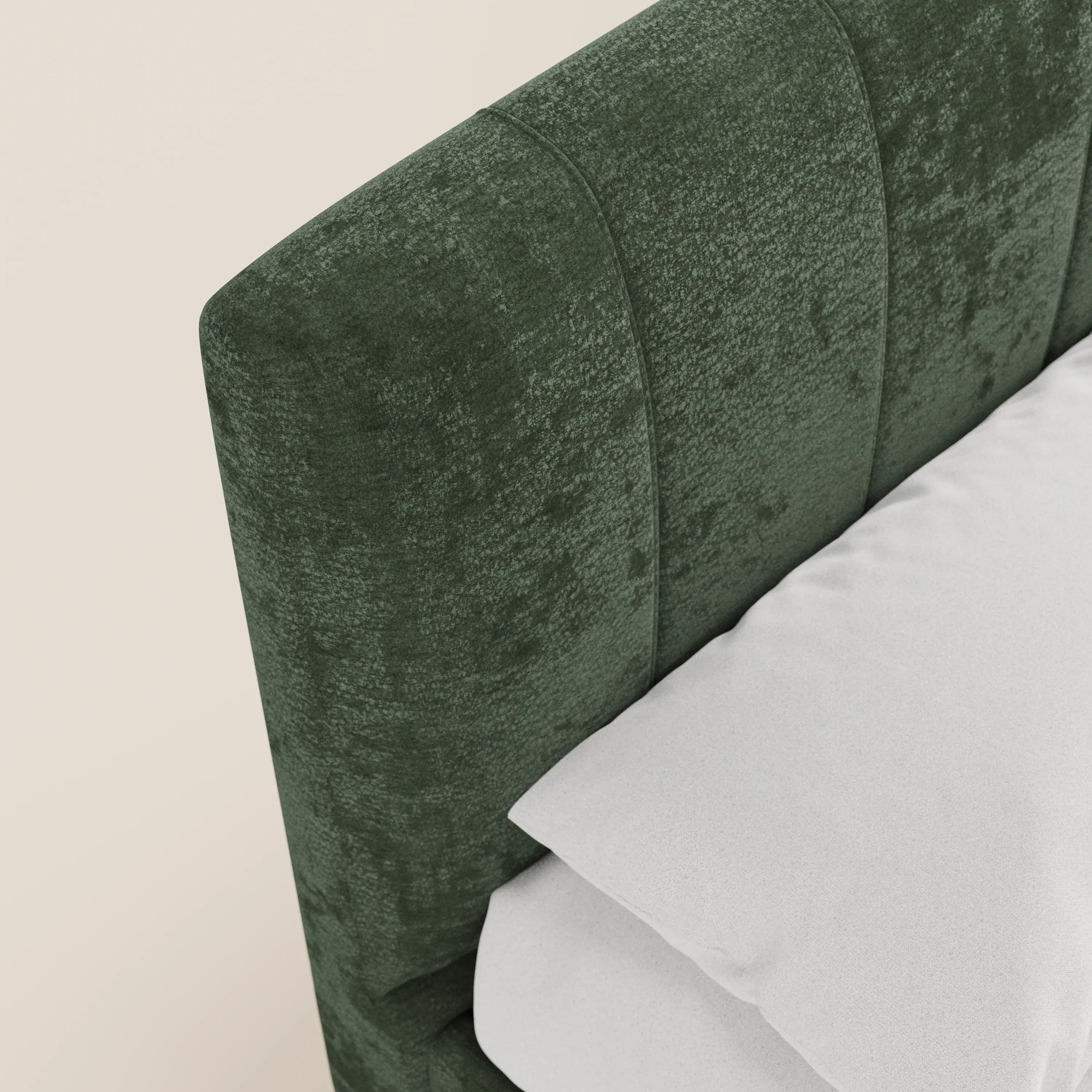 Primo piano del letto imbottito ONYX con contenitore e testiera verticale in tessuto Oeko-Tex® di Letti.store, caratterizzato da cuciture verticali verdi. Il letto, rifinito con cura e rivestito con biancheria da letto bianca, è addossato a una parete semplice color avorio.