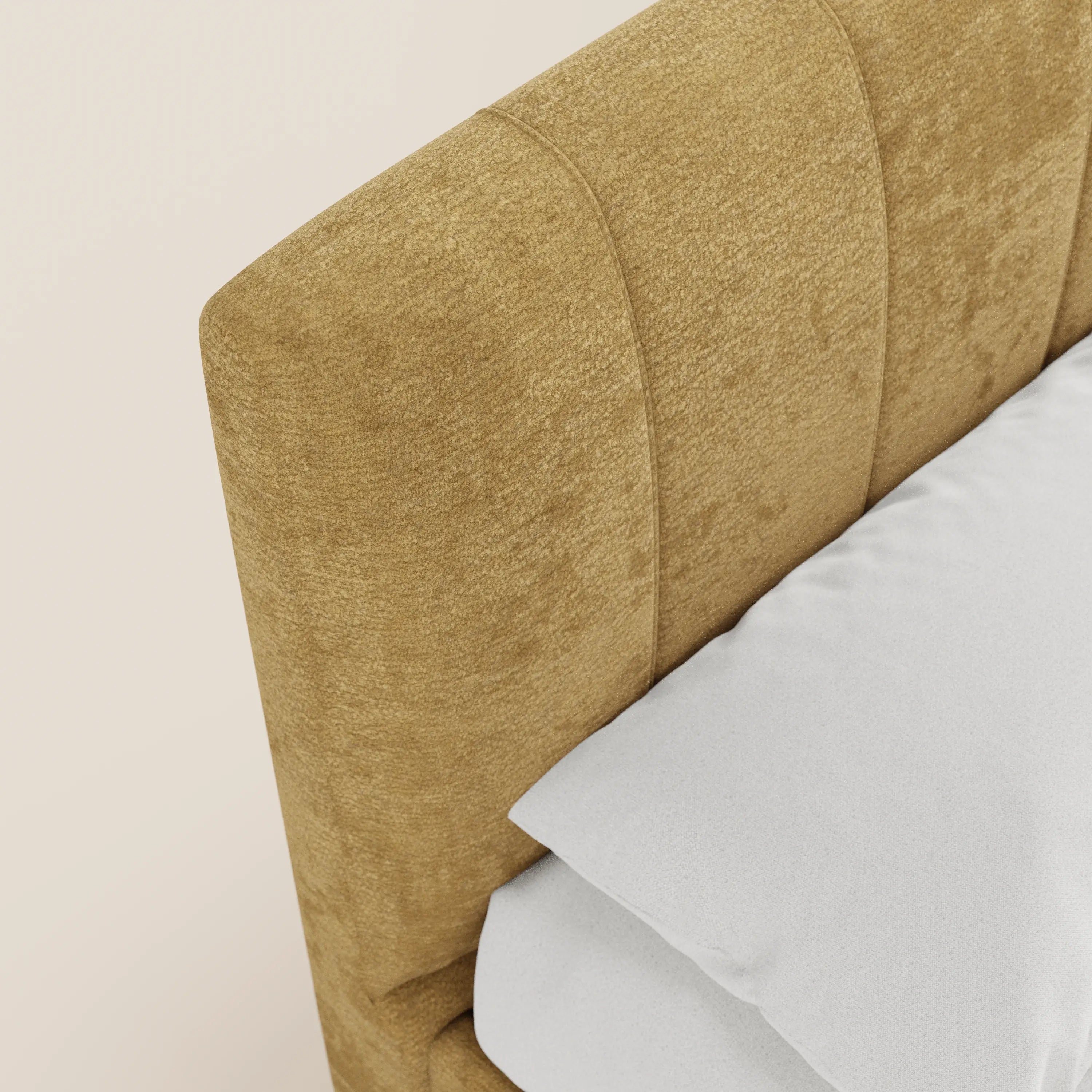 Primo piano del letto imbottito ONYX di Letti.store, caratterizzato da una testiera in tessuto giallo senape certificato Oeko-Tex® con cuciture verticali, raffigurato accanto a un letto ben rifatto con biancheria da letto bianca su uno sfondo chiaro.