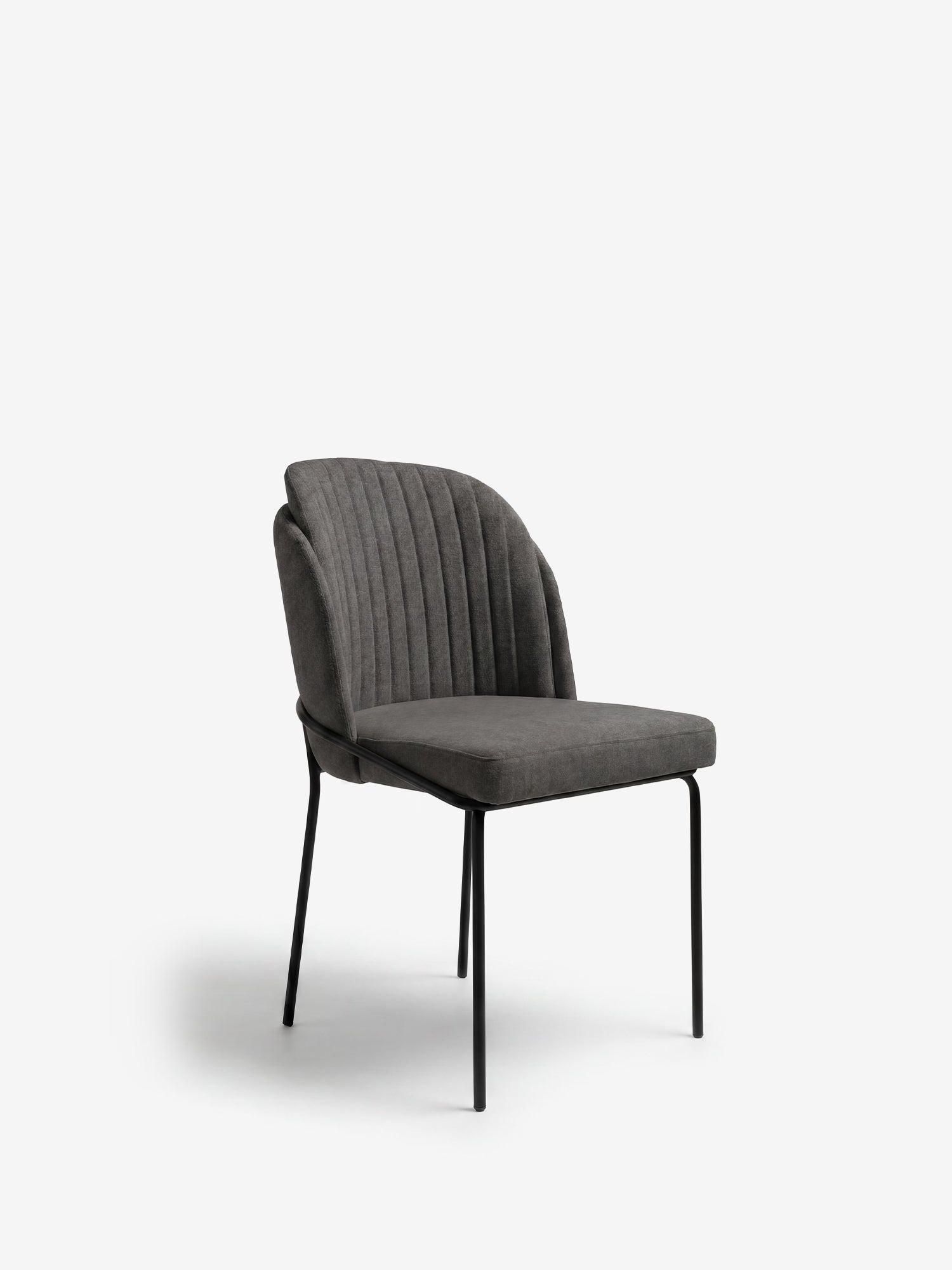 La sedia imbottita Plissè di Divani.Store è caratterizzata da un tessuto impermeabile, uno schienale plissettato e sottili gambe in metallo nero. Il suo design moderno risalta sullo sfondo grigio chiaro, unendo eleganza e stile contemporaneo.