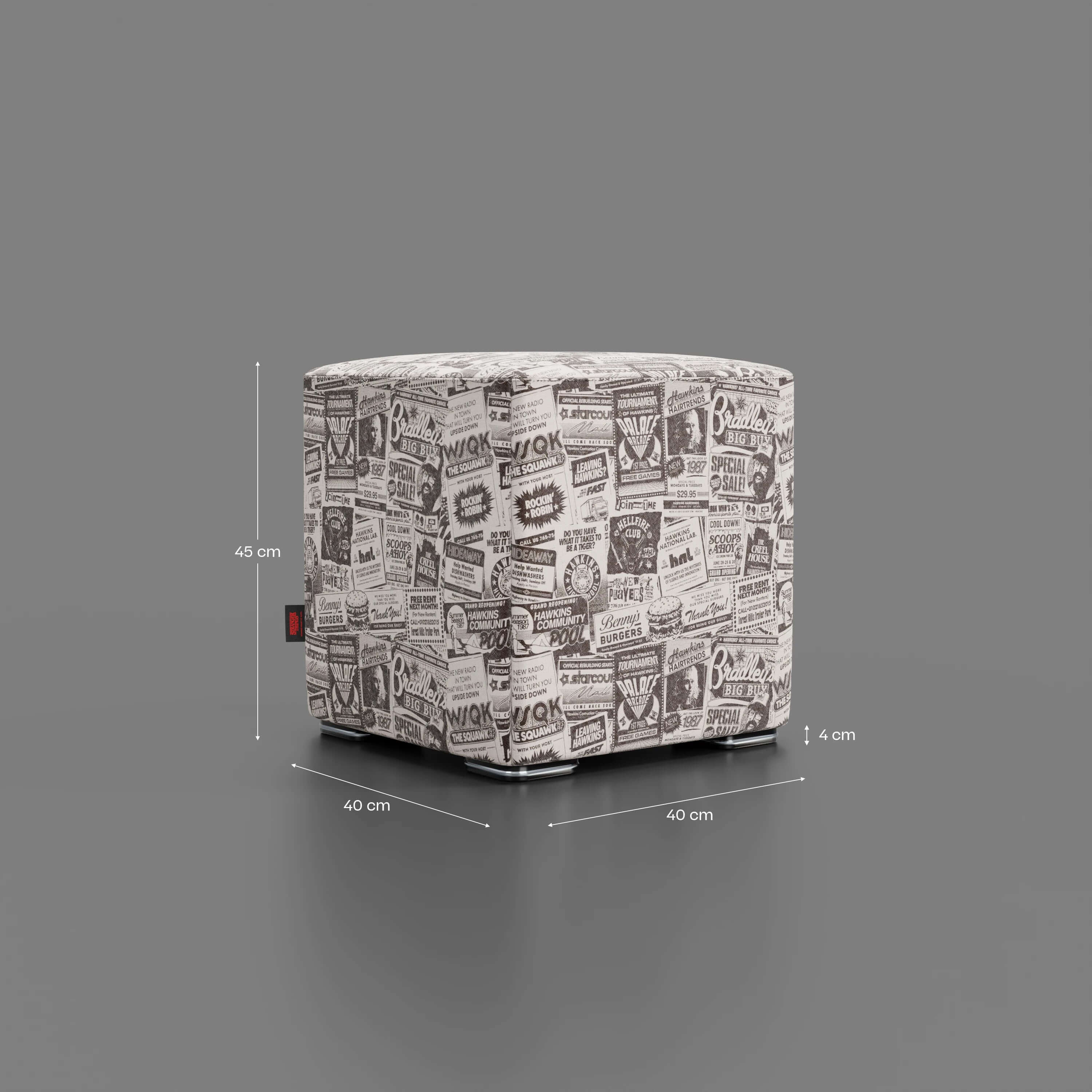 Il pouf Cube Hawkins Post Stranger Things - Limited Edition Netflix di Divani.Store è un pouf quadrato con stampa vintage in bianco e nero, sfondo grigio, linee di misura visibili e misura 45 cm di altezza per 40 cm di larghezza/profondità.