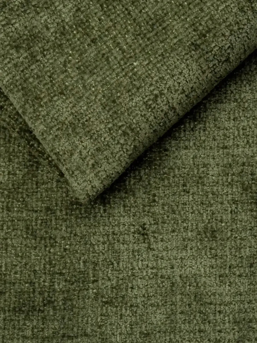 Primo piano del tessuto verde muschio, dalla trama a riccioli e dalla consistenza materica, su un divano letto Ottaviano con letto estraibile – penisola reversibile e contenitore in tessuto materico lavabile, che mostra un angolo ripiegato per rivelare il folto pelo.