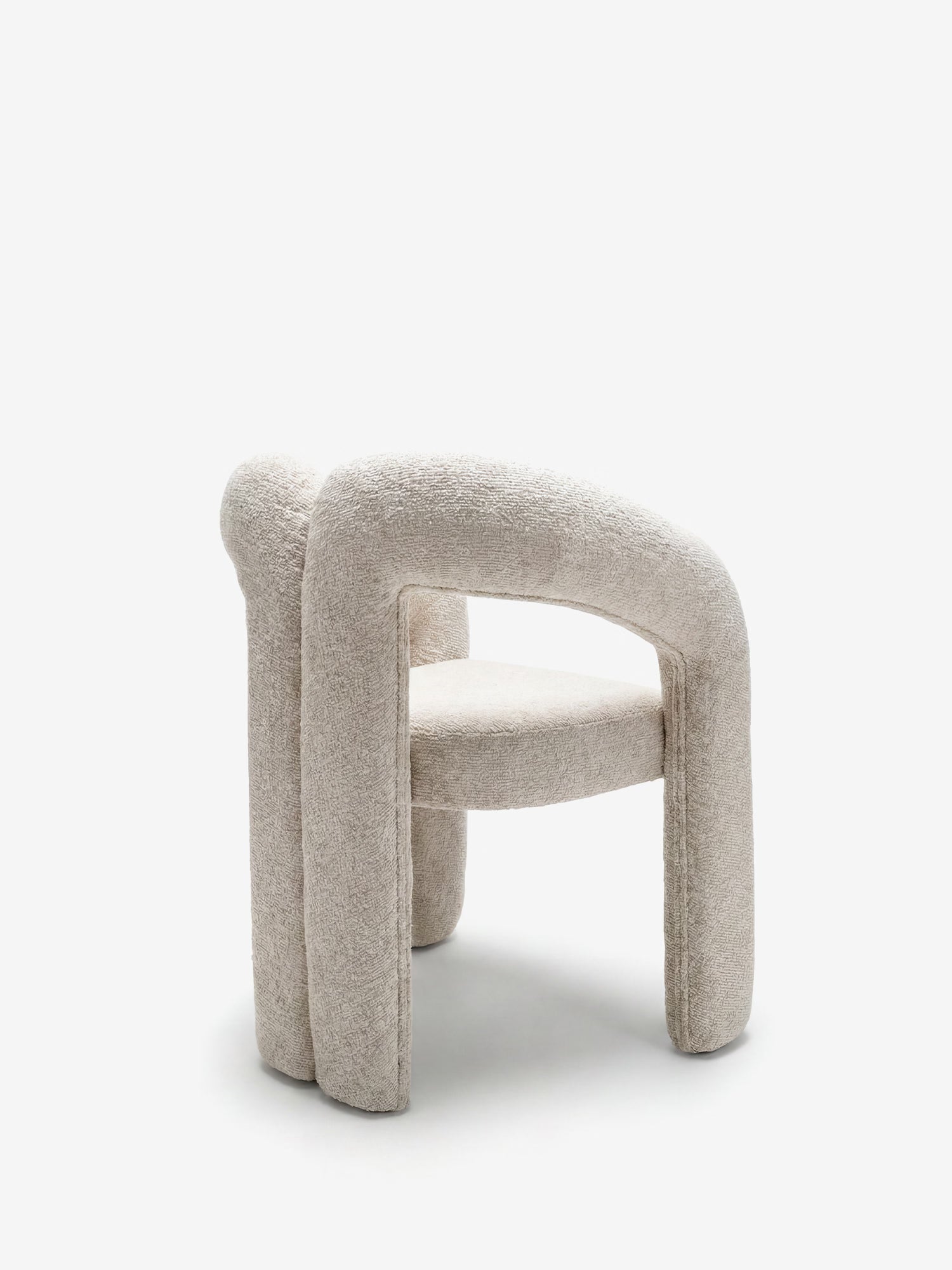 La sedia di design Sibilla di Divani.Store è interamente rivestita in tessuto beige testurizzato, con struttura rivestita e forma arcuata. Il suo look elegante e moderno è caratterizzato da gambe e schienale arrotondati, che risaltano su uno sfondo bianco a tinta unita.
