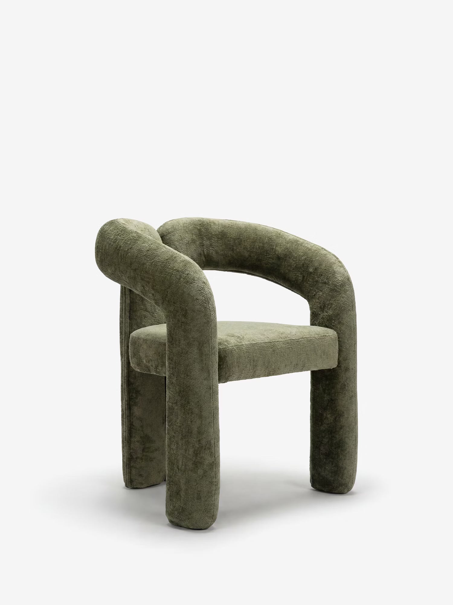 La sedia di design imbottita Sibilla di Divani.Store è interamente rivestita in tessuto verde oliva e presenta uno schienale curvo e braccioli tubolari su gambe robuste, che le conferiscono un aspetto scultoreo e contemporaneo.