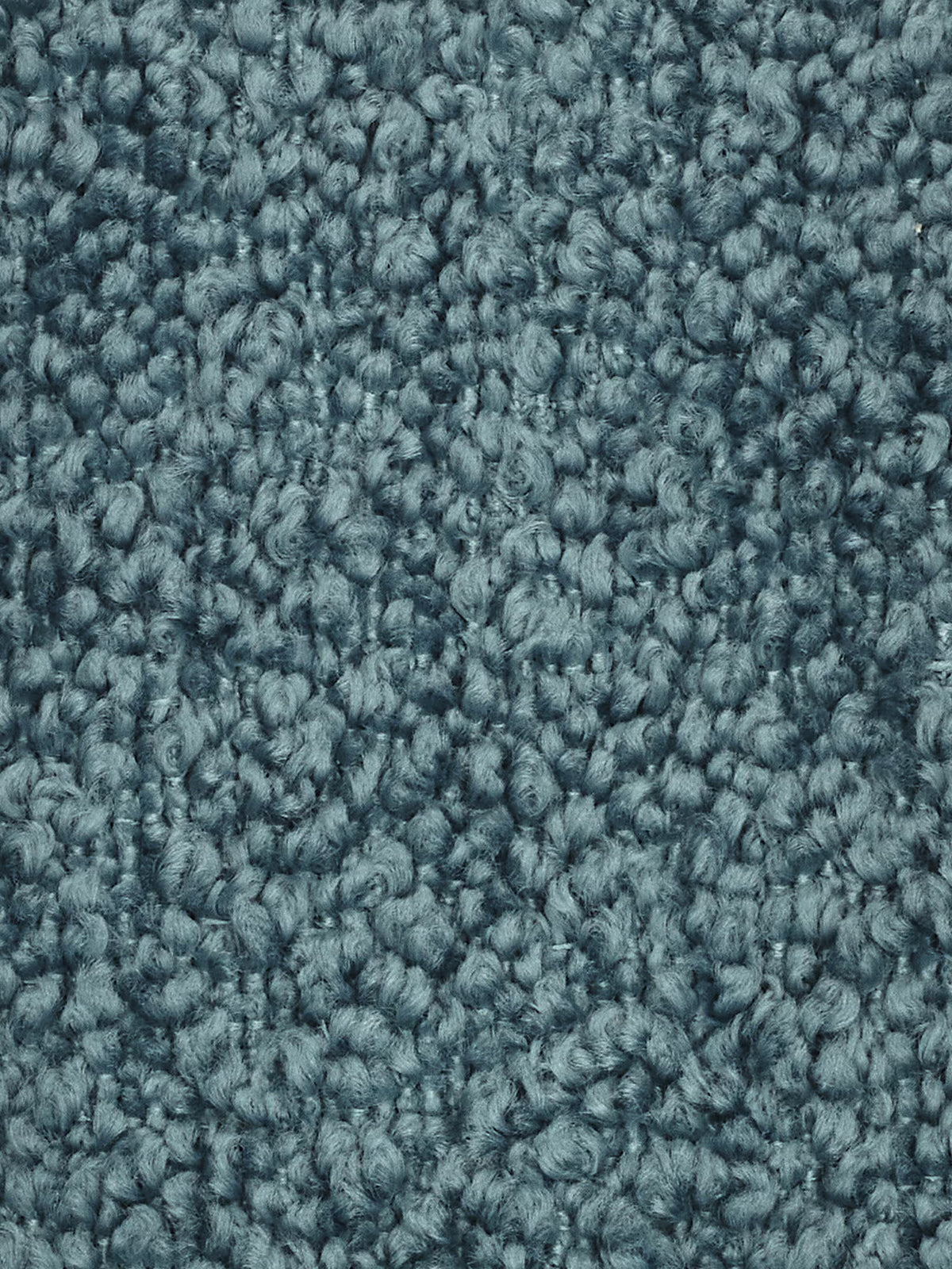 Primo piano di un tappeto a riccioli blu, che mostra fibre intrecciate a trama fitta e strutturate che creano una superficie morbida e irregolare. I filati sono uniformi per dimensioni e colore, conferendo al tappeto un aspetto soffice e omogeneo con una delicata lucentezza: una base ideale per disporre un divano modulare o qualsiasi elemento centrale di un soggiorno moderno. Nessuna macchia o segno di usura visibile.