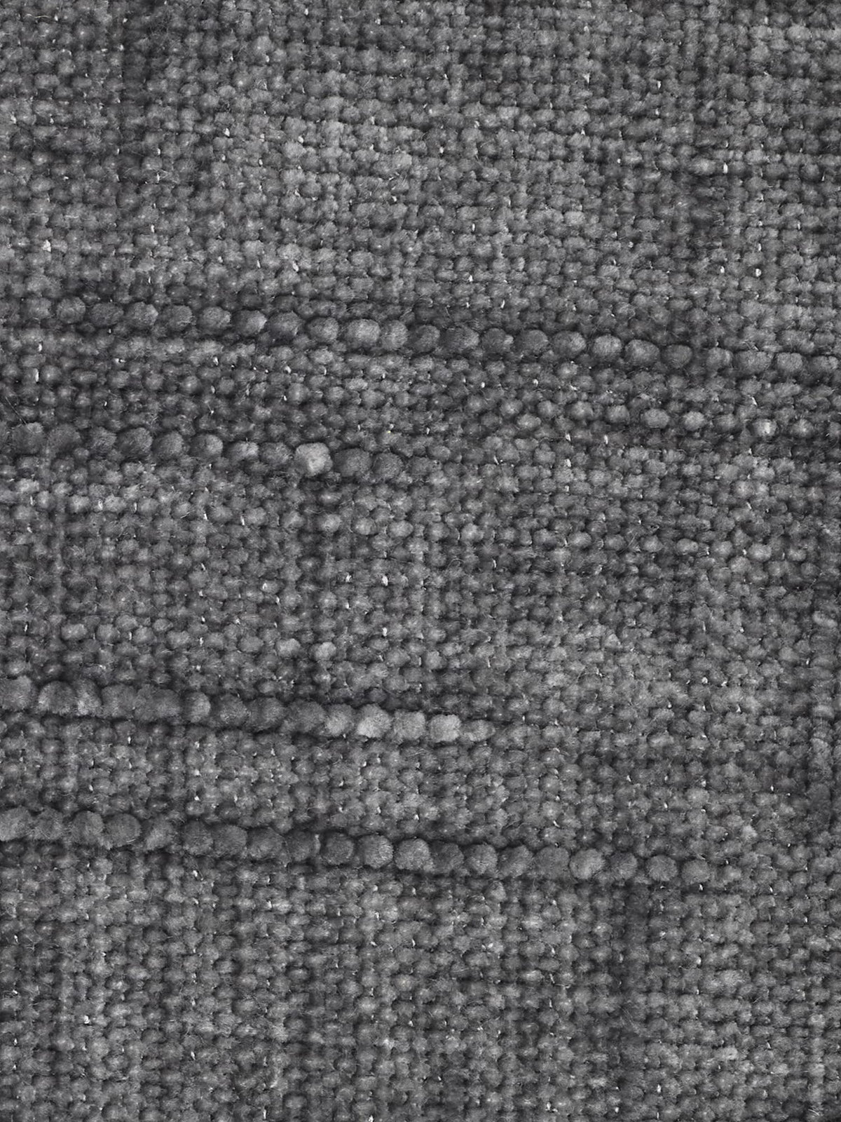 Primo piano del rivestimento in tessuto jacquard grigio a trama in rilievo del divano letto angolare Pegaso con poggiatesta reclinabili e penisola contenitore in tessuto jacquard smacchiabile T22 di Divani.Store. Il tessuto presenta un motivo a griglia formato dall’intersezione di linee orizzontali e verticali, con fili a vista e diverse sfumature di grigio che conferiscono profondità e un aspetto delicatamente morbido ma leggermente ruvido. Non sono visibili altri oggetti.