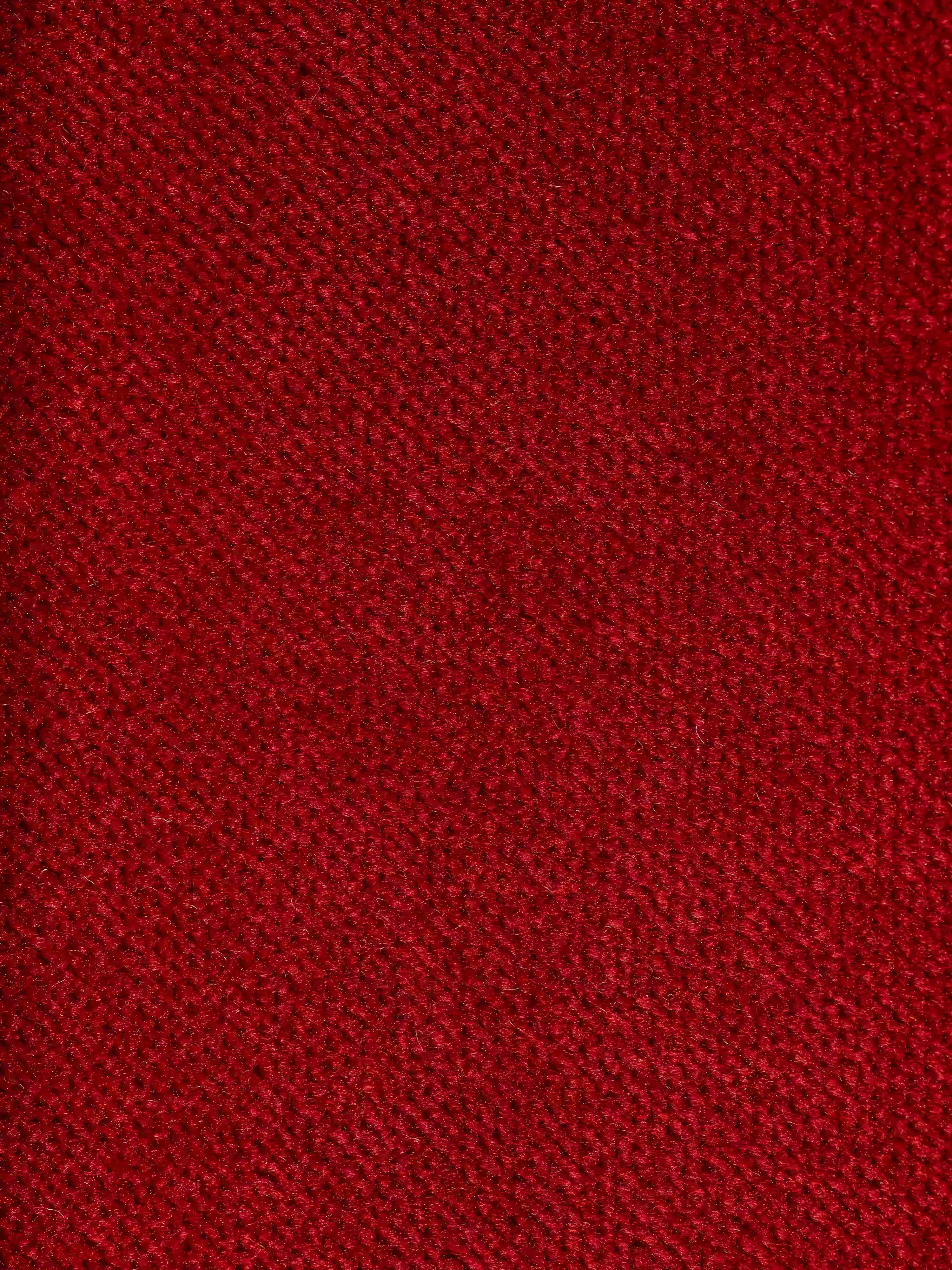 Un primo piano del raffinato tessuto rosso smacchiabile effetto vellutino T30 utilizzato per il divano angolare Michelangelo con penisola e sedute estensibili di Divani.Il tessuto presenta una trama morbida e leggermente sfocata, con una trama uniforme e delicate variazioni di tonalità dovute al gioco di luci e ombre: una scelta ideale per rivestire la vostra zona relax configurabile.