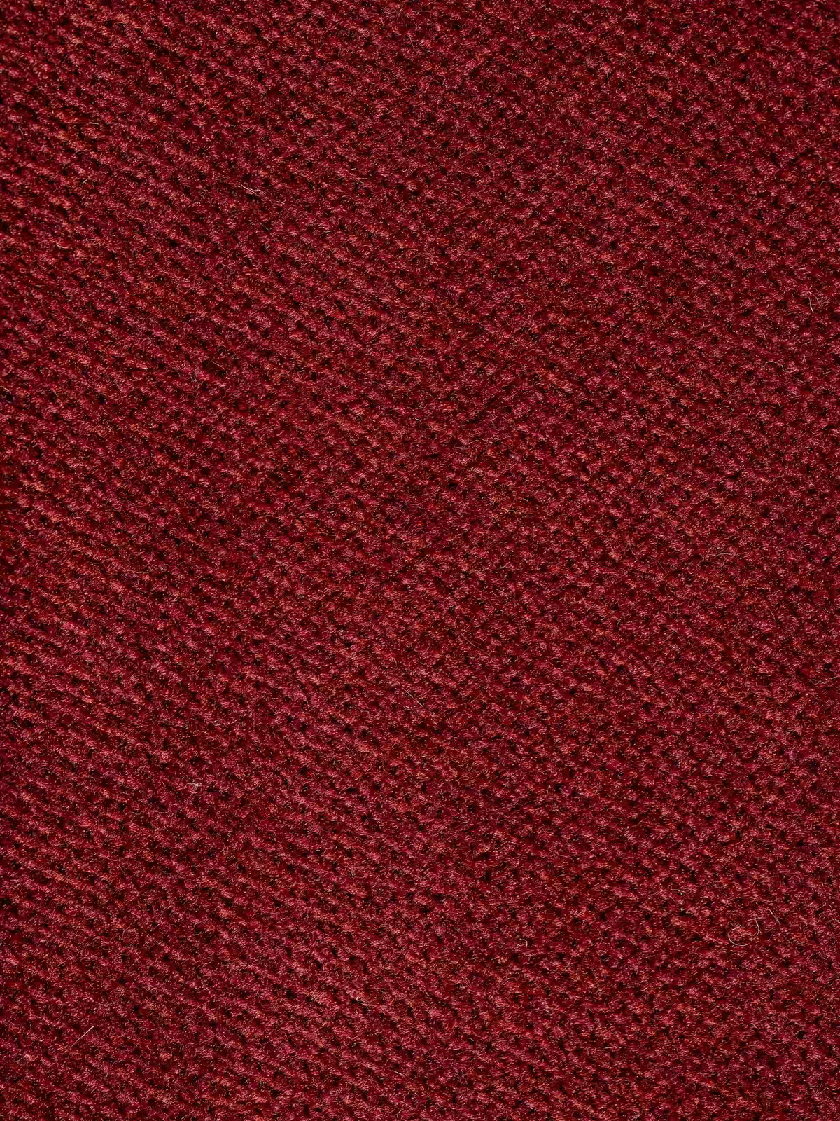 Primo piano del divano letto di design Capri con piedini alti di Divani.Store, che mette in risalto il suo raffinato rivestimento rosso a trama in tessuto smacchiabile T30 effetto velluto. La superficie rivela un delicato motivo diagonale in diverse tonalità di rosso e bordeaux, che mette in risalto la maestria della manifattura italiana e il sofisticato effetto intrecciato, ideale per gli interni moderni.