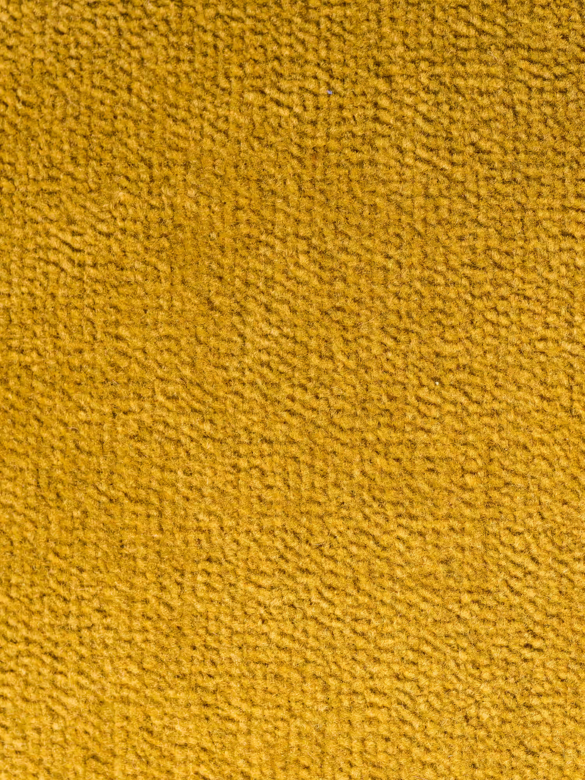 Primo piano del tessuto giallo senape utilizzato per il divano angolare con penisola e sedute scorrevoli in tessuto smacchiabile T31 “Caravaggio” di Divani.Store. La superficie presenta una trama uniforme e a maglie fitte che conferisce un aspetto morbido e accogliente, mentre la luce ne accentua la profondità e proietta sottili ombre tra le maglie: ideale per un rivestimento resistente.