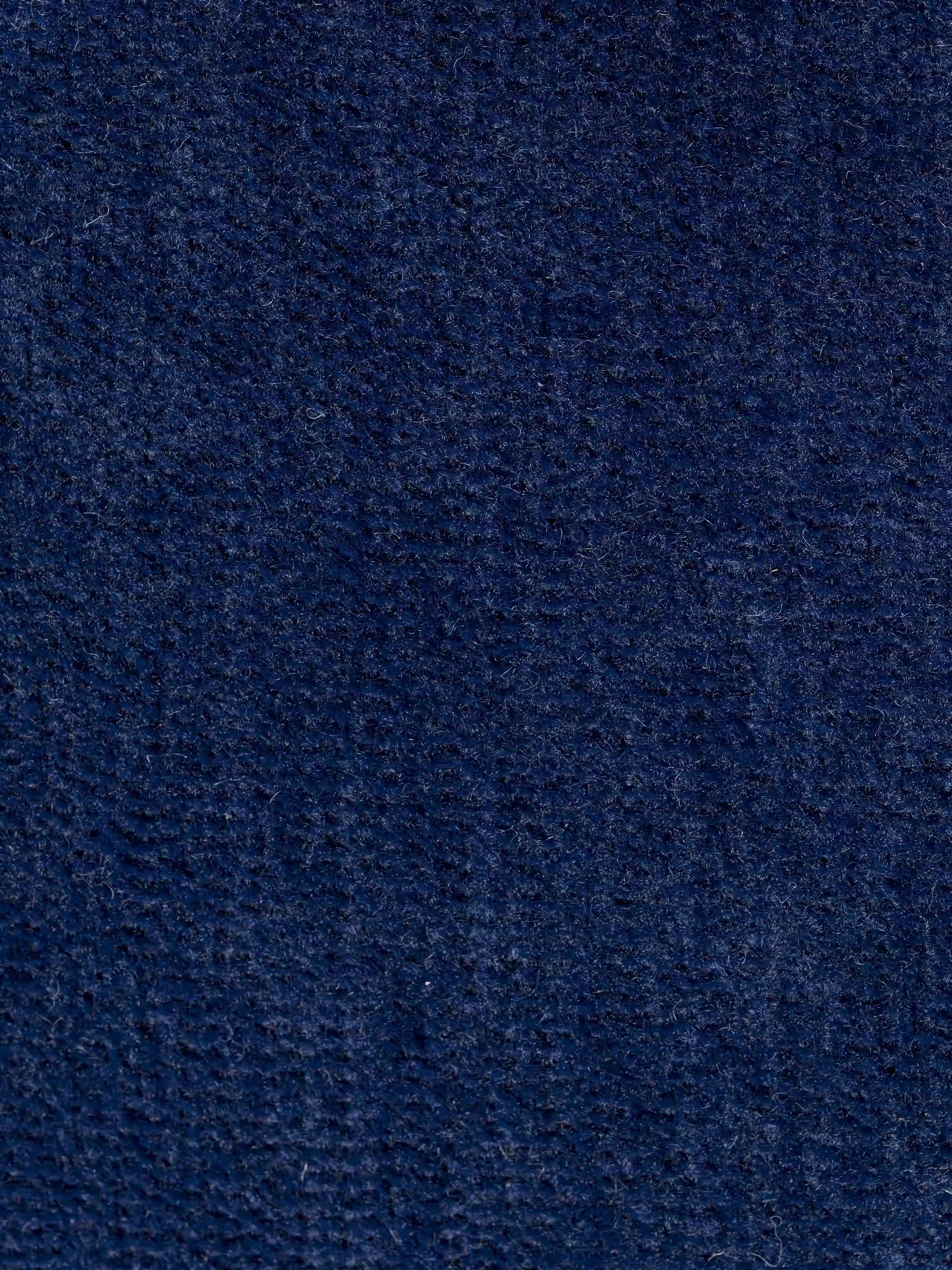 Primo piano su un tessuto blu scuro dalla trama rigata, probabilmente denim o velluto a coste, presente sul divano letto matrimoniale Rift a 2 e 3 posti con schienali mobili di Divani.Store. La superficie presenta motivi intrecciati ben definiti e leggermente irregolari, che creano un effetto morbido e piacevole al tatto con delicate variazioni di sfumature e profondità: caratteristiche che si integrano perfettamente con il comfort superiore del suo materasso in memory foam T31, alto 22 cm.