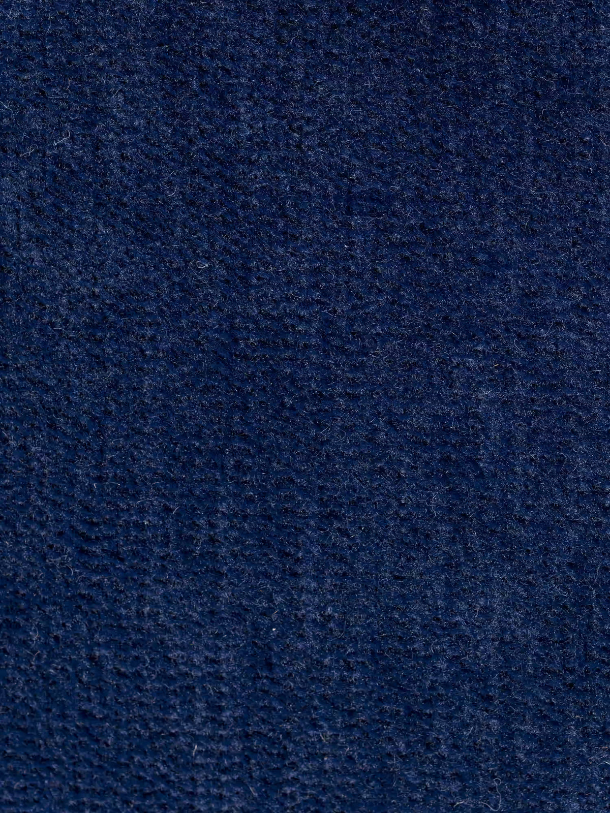 Primo piano del tessuto T31 blu scuro, testurizzato e antimacchia della collezione Divani.Store Rift, una poltrona letto con materasso alto 24 cm e memory foam, caratterizzata da una superficie leggermente felpata e morbida e da un motivo a trama visibile. L’estetica minimalista del design è esaltata da sottili variazioni di tonalità e trama — che ricordano i raffinati rivestimenti delle poltrone letto — con un tocco in più di praticità e stile.