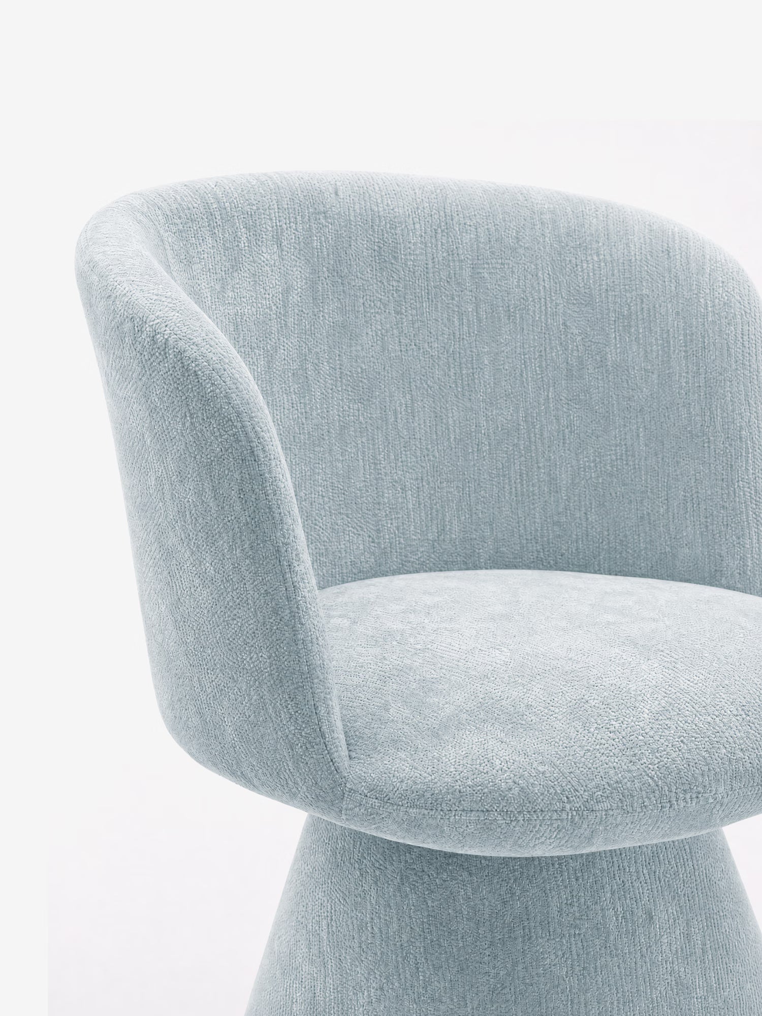 Un primo piano della sedia moderna imbottita Talia di Divani.Store, realizzata in tessuto ciniglia OEKO-TEX® azzurro, caratterizzata da uno schienale arrotondato, braccioli ricurvi e un design minimalista senza cuciture, su uno sfondo bianco a tinta unita.