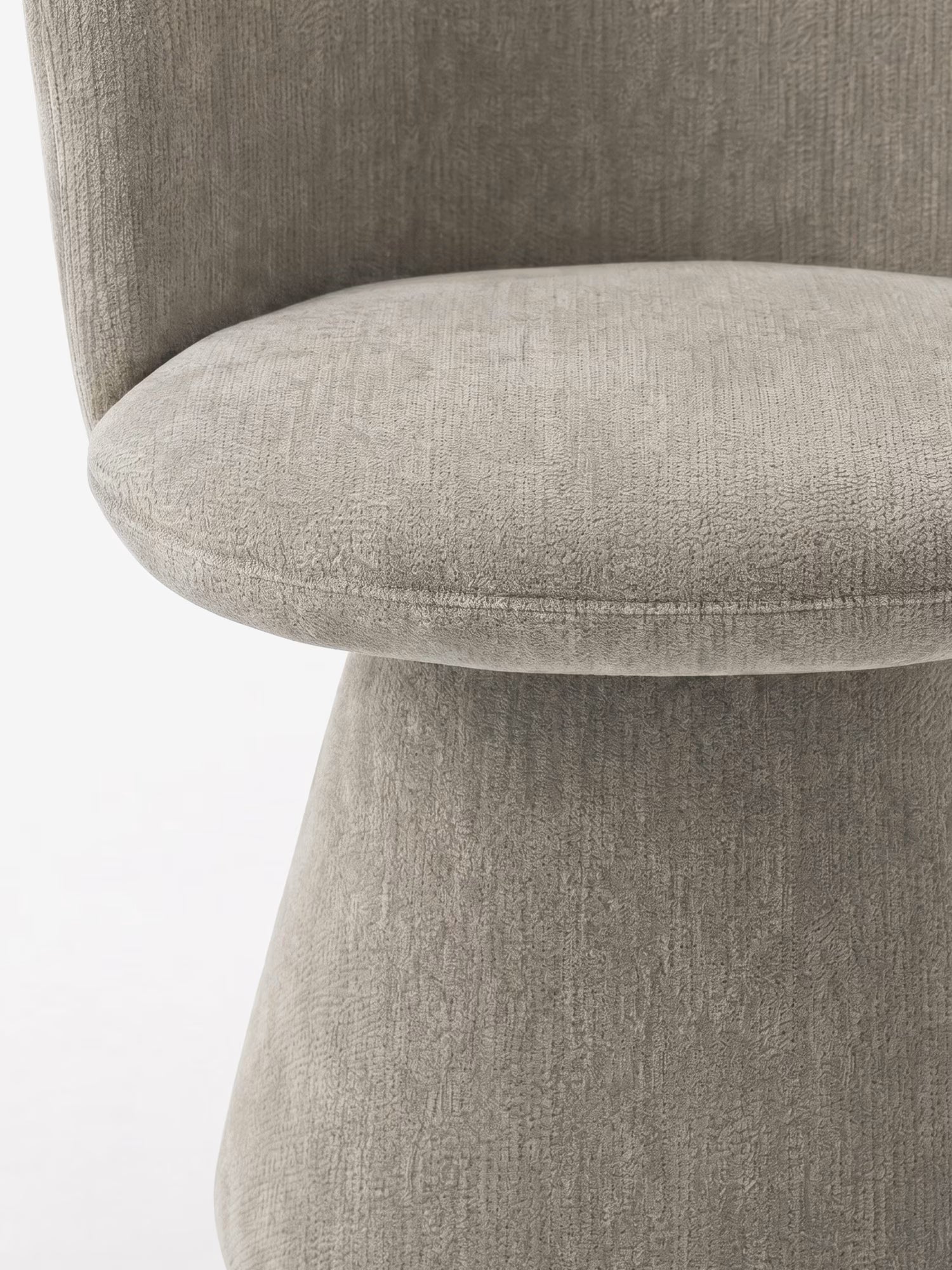 Primo piano della sedia moderna Talia di Divani.Store, rivestita in morbido tessuto ciniglia certificato OEKO-TEX® con seduta arrotondata e schienale curvo. La base interamente imbottita conferisce un aspetto omogeneo e lussuoso sullo sfondo bianco.