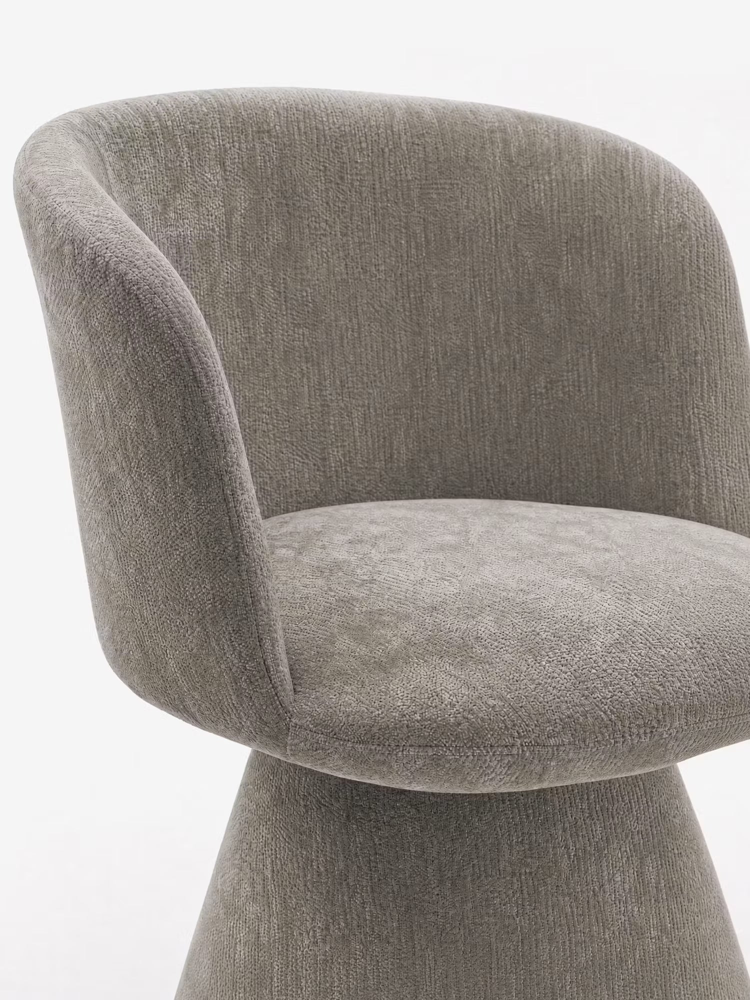 La sedia moderna imbottita Talia di Divani.Store presenta una seduta ampia e arrotondata e uno schienale curvo, rivestiti in morbido tessuto ciniglia grigio testurizzato certificato OEKO-TEX®, con una base conica abbinata che conferisce al tutto un aspetto elegante e armonioso.