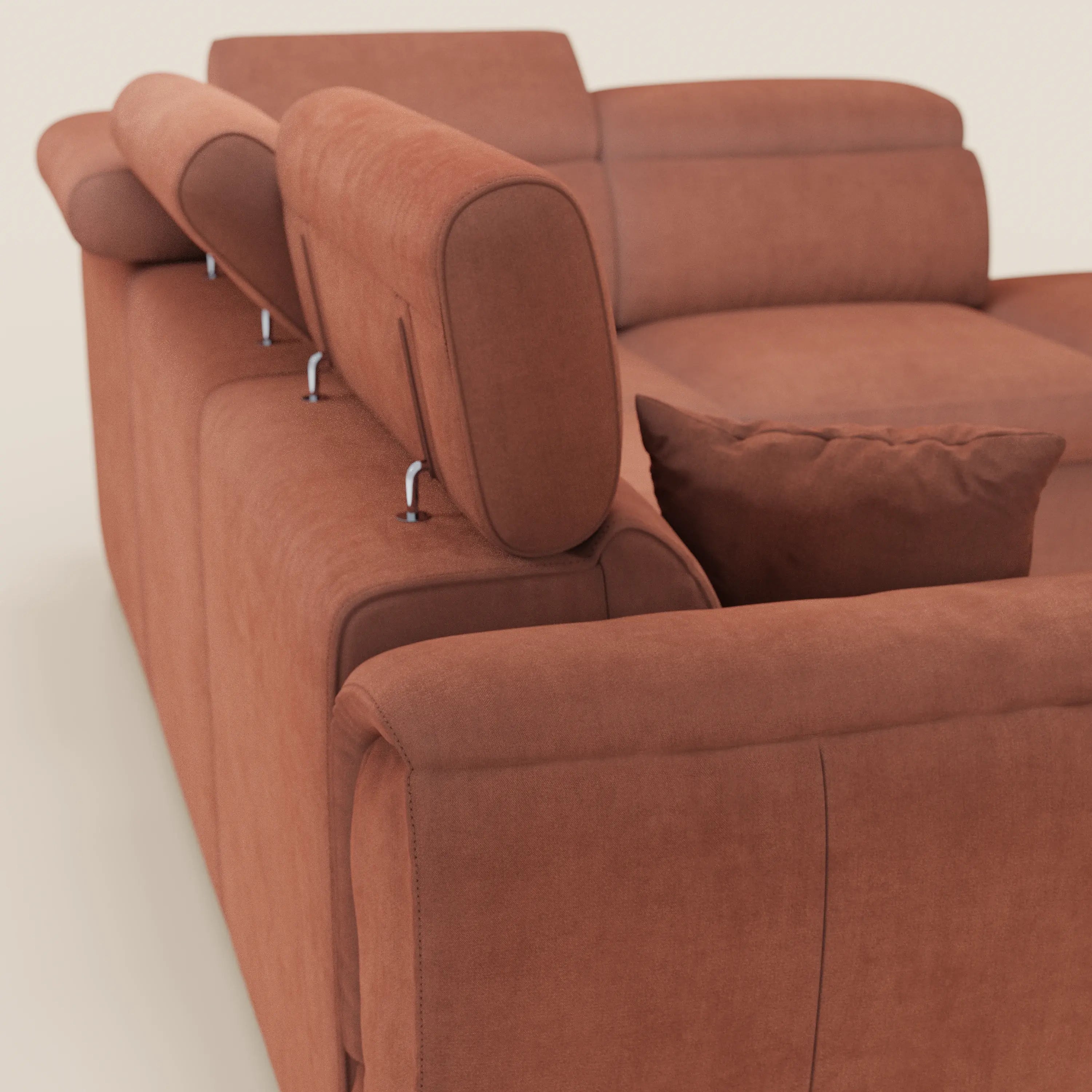 Un primo piano del divano angolare reversibile Titano di Divani.Store, presentato in tessuto rosso-marrone Oeko-Tex® antimacchia, con poggiatesta reclinabili, morbidi cuscini dello schienale e un pouf contenitore abbinato, su uno sfondo chiaro.