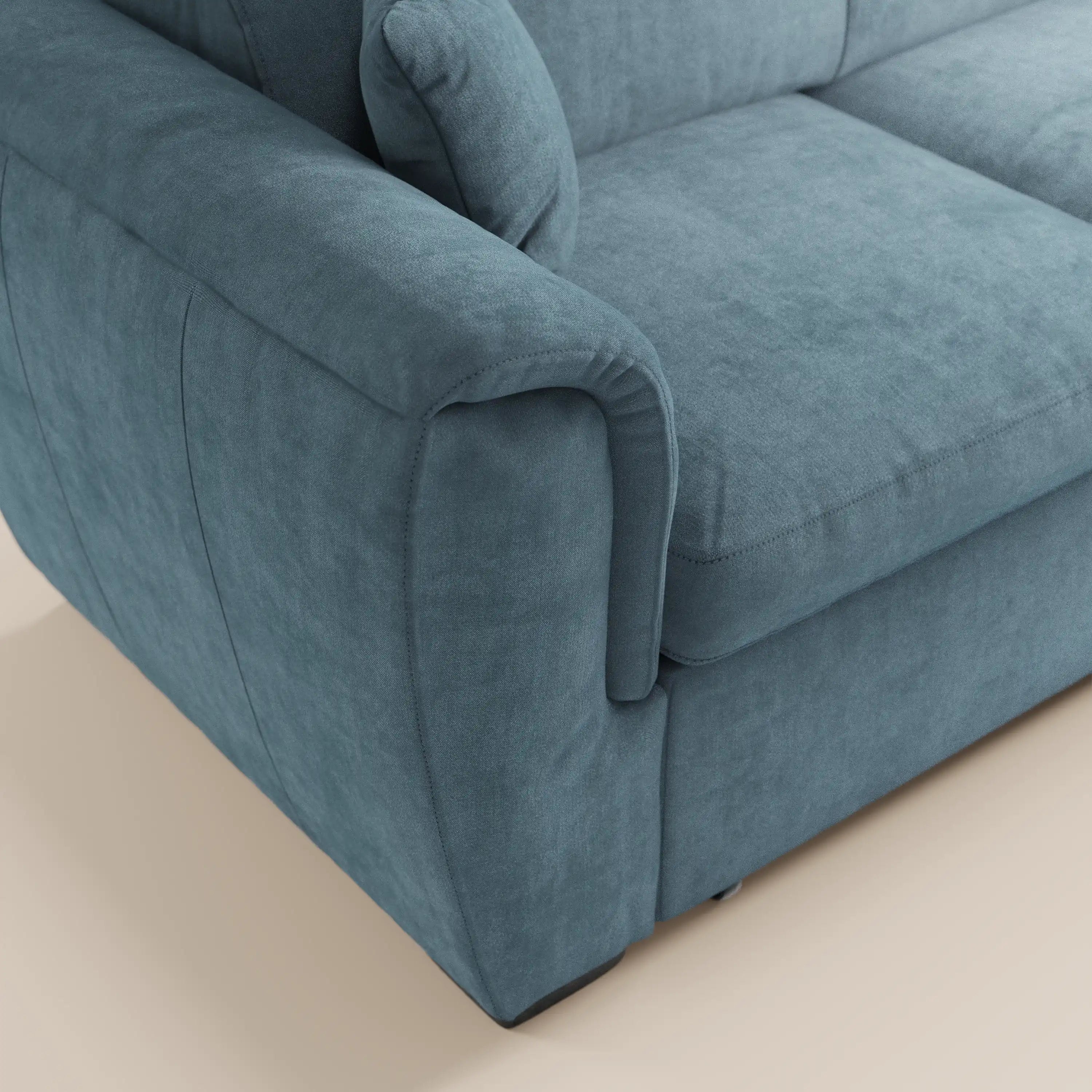 Primo piano del divano angolare reversibile Titano di Divani.Store in colore verde acqua, con morbidi cuscini, ampi braccioli imbottiti, cuciture rifinite e morbido tessuto Oeko-Tex® antimacchia — raffigurato su un pavimento chiaro.