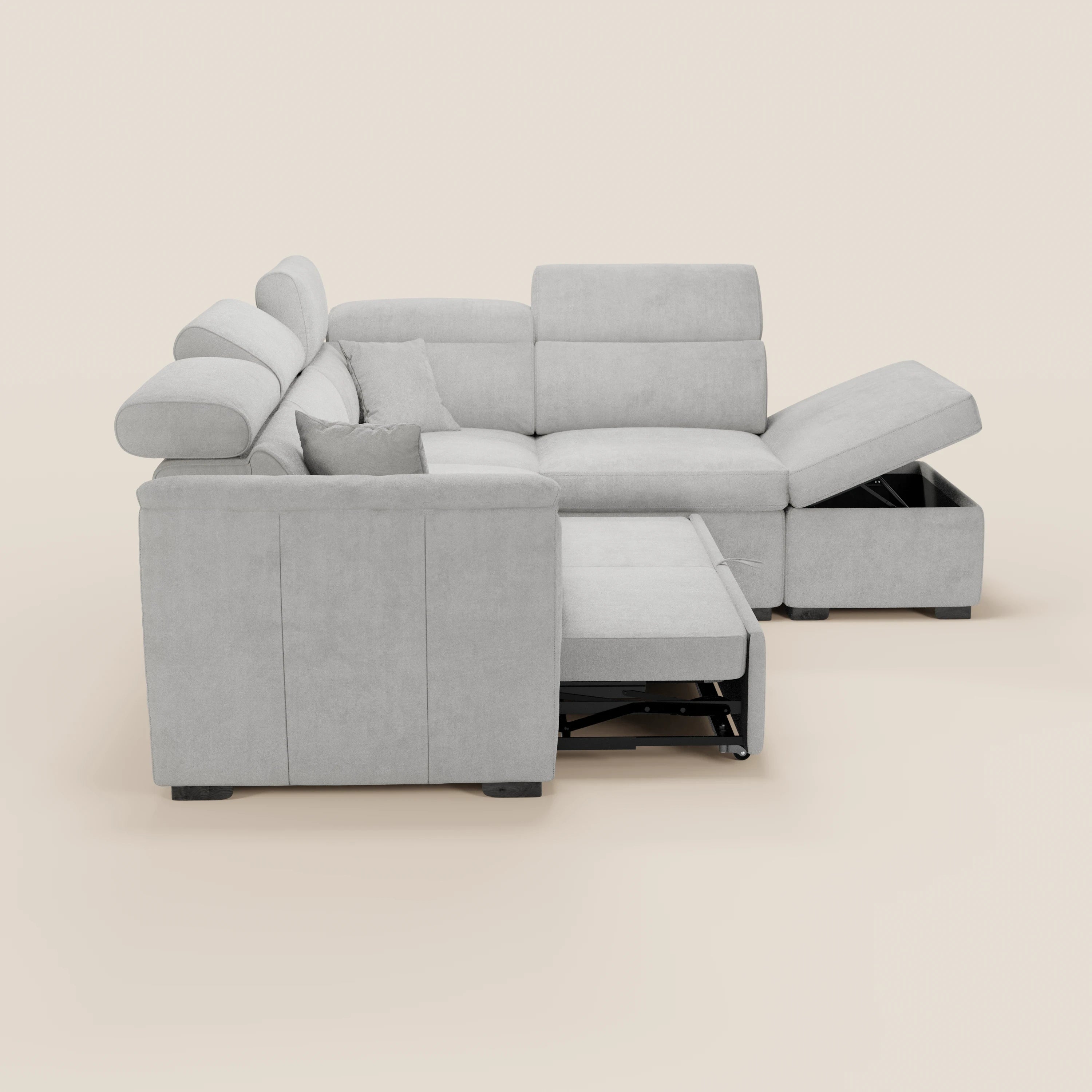 Il divano angolare reversibile Titano di Divani.Store, in tessuto smacchiabile Oeko-Tex®, è dotato di poggiatesta reclinabili, un pouf contenitore e una chaise longue con vano portaoggetti. Sullo sfondo: beige chiaro uniforme.
