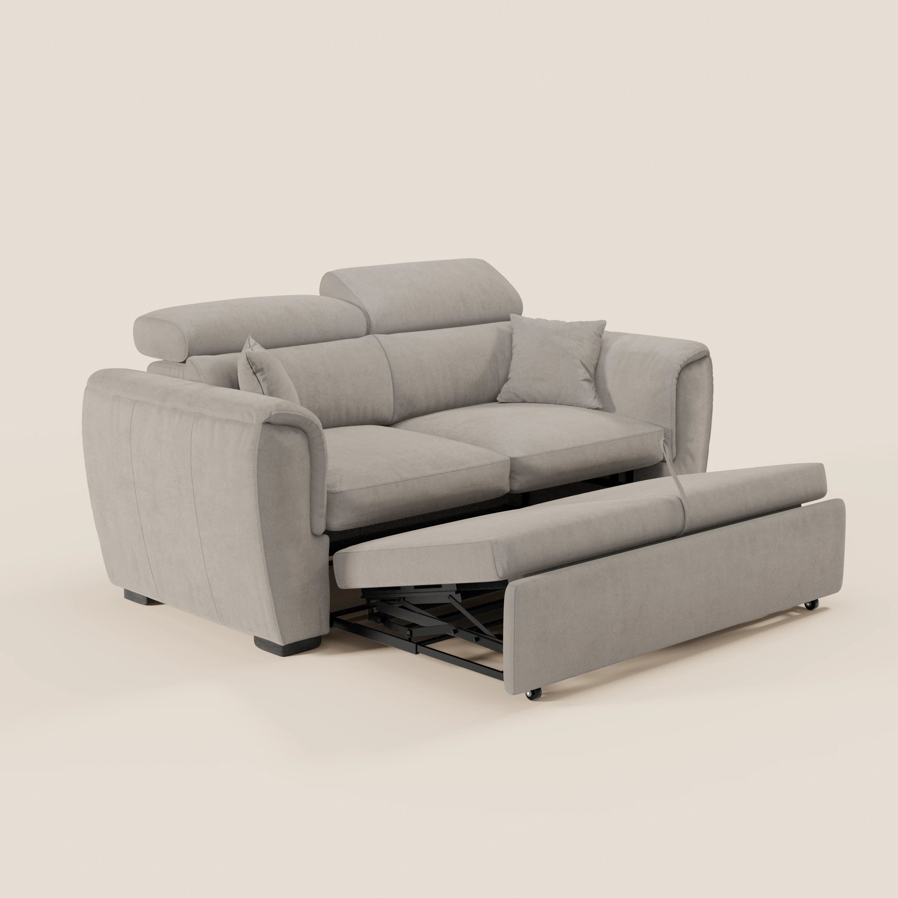 Il divano a 2 posti estraibile Titano di Divani.Store, realizzato in tessuto grigio chiaro Oeko-Tex® antimacchia con cuscini imbottiti e poggiatesta regolabili, è dotato di un poggiapiedi estraibile a scomparsa su supporti in metallo nero su sfondo beige.