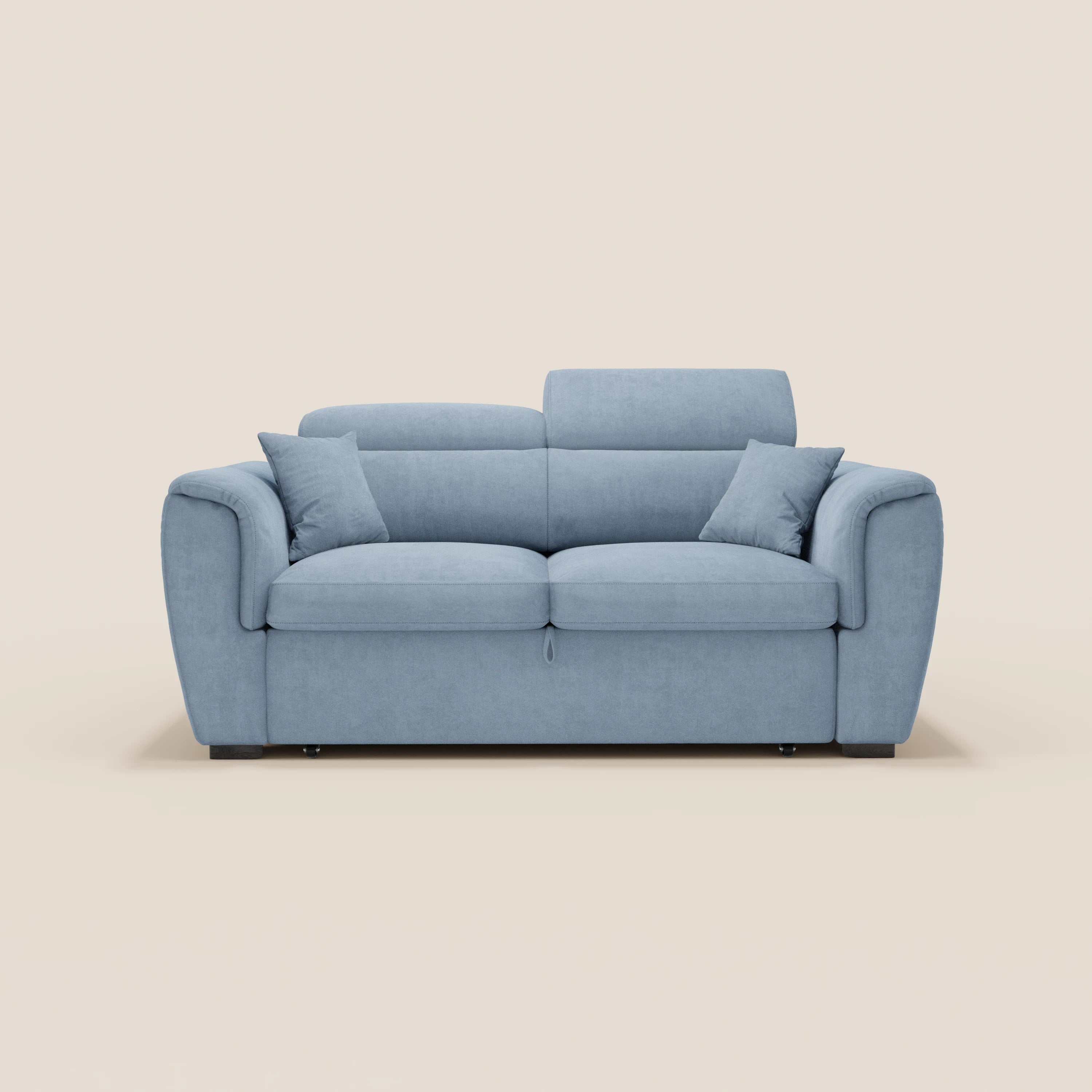 Il divano a 2 posti estraibile Titano di Divani.Store, realizzato in tessuto smacchiabile Oeko-Tex®, è dotato di poggiatesta reclinabili, due cuscini per la seduta e lo schienale, quattro cuscini quadrati e ampi braccioli dal design moderno su uno sfondo bianco sporco.