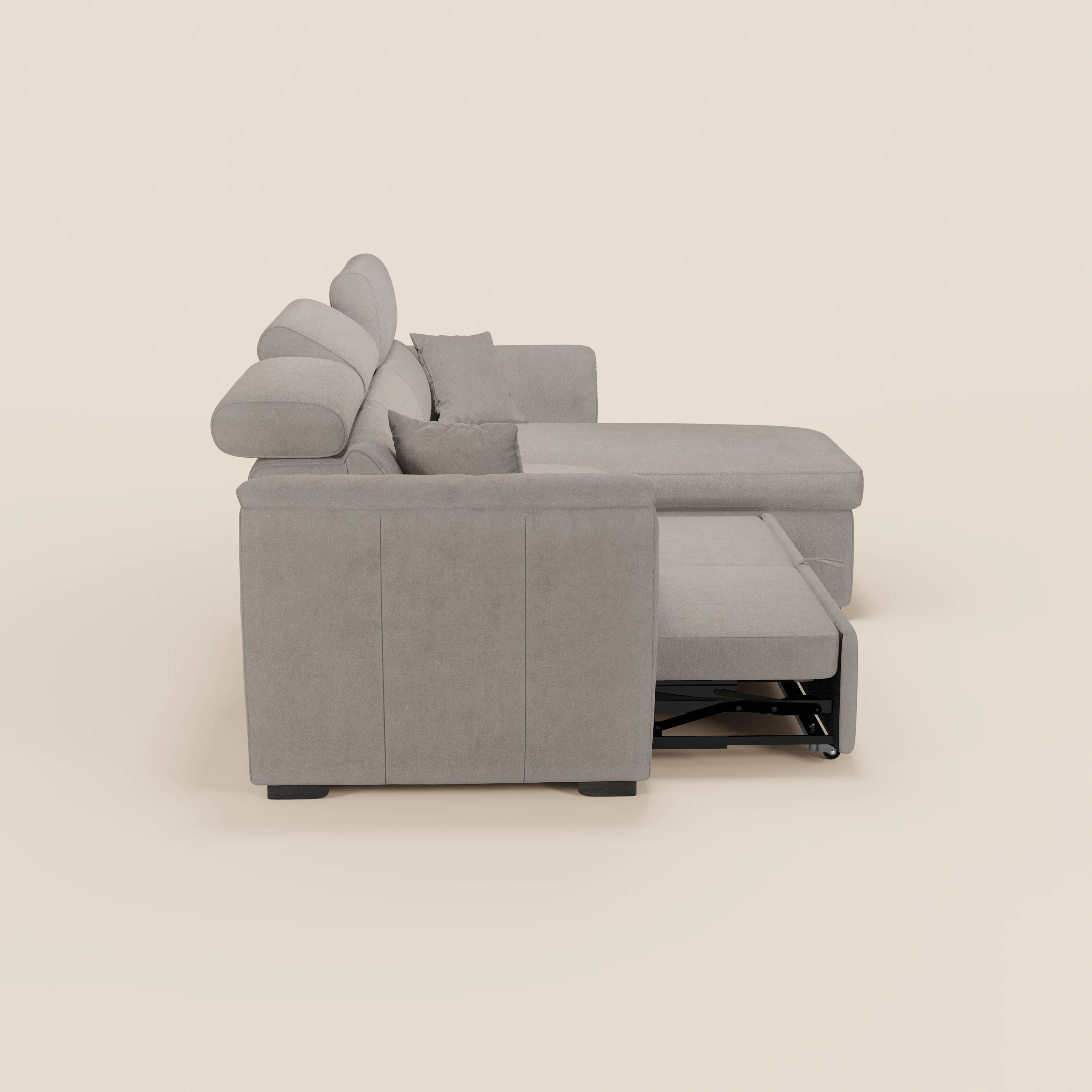 Il divano letto Titano di Divani.Store è dotato di una chaise longue reversibile con vano portaoggetti, poggiatesta reclinabili e un letto estraibile in tessuto facile da pulire, completo di morbidi cuscini e due cuscini coordinati in grigio chiaro su sfondo beige.