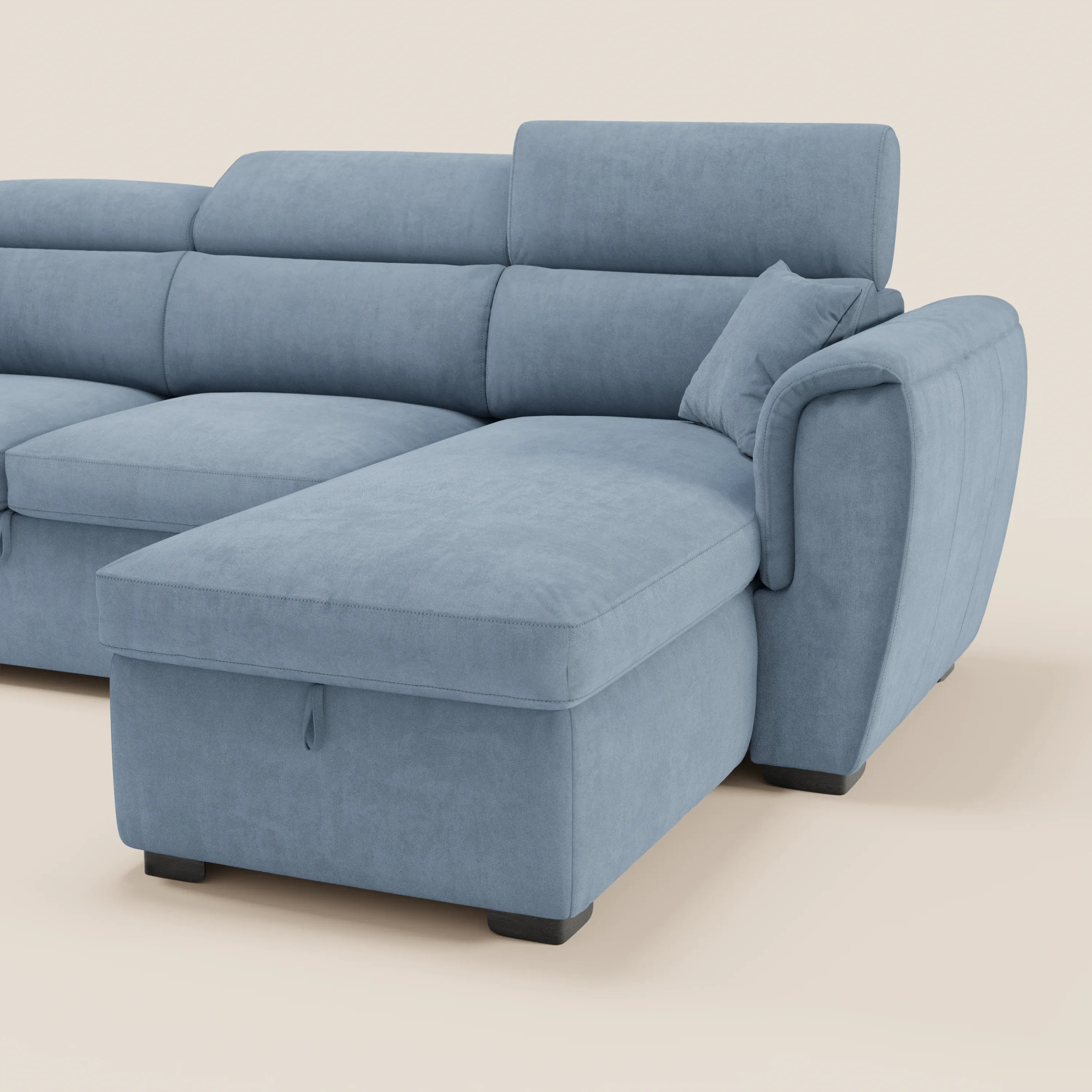 Il divano letto Titano di Divani.Store è dotato di una chaise longue reversibile con vano contenitore, poggiatesta reclinabili e un elemento estraibile; è rivestito in tessuto antimacchia, qui presentato in una delicata tonalità di blu su uno sfondo beige chiaro a tinta unita.