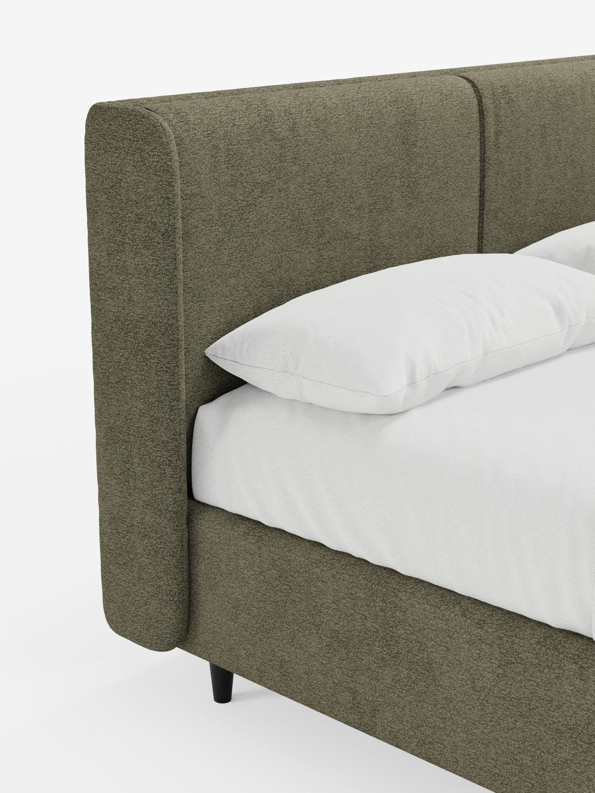 Un primo piano del letto di design VALKIRIA con contenitore e testiera avvolgente di Letti.store mette in risalto un angolo letto imbottito in tessuto Oeko-Tex® verde oliva a trama ruvida, caratterizzato da un’alta testiera imbottita con due morbidi cuscini. Il design contemporaneo prevede un cuscino bianco e la biancheria da letto disposti sulla struttura, che poggia su corte gambe nere su uno sfondo chiaro e semplice.