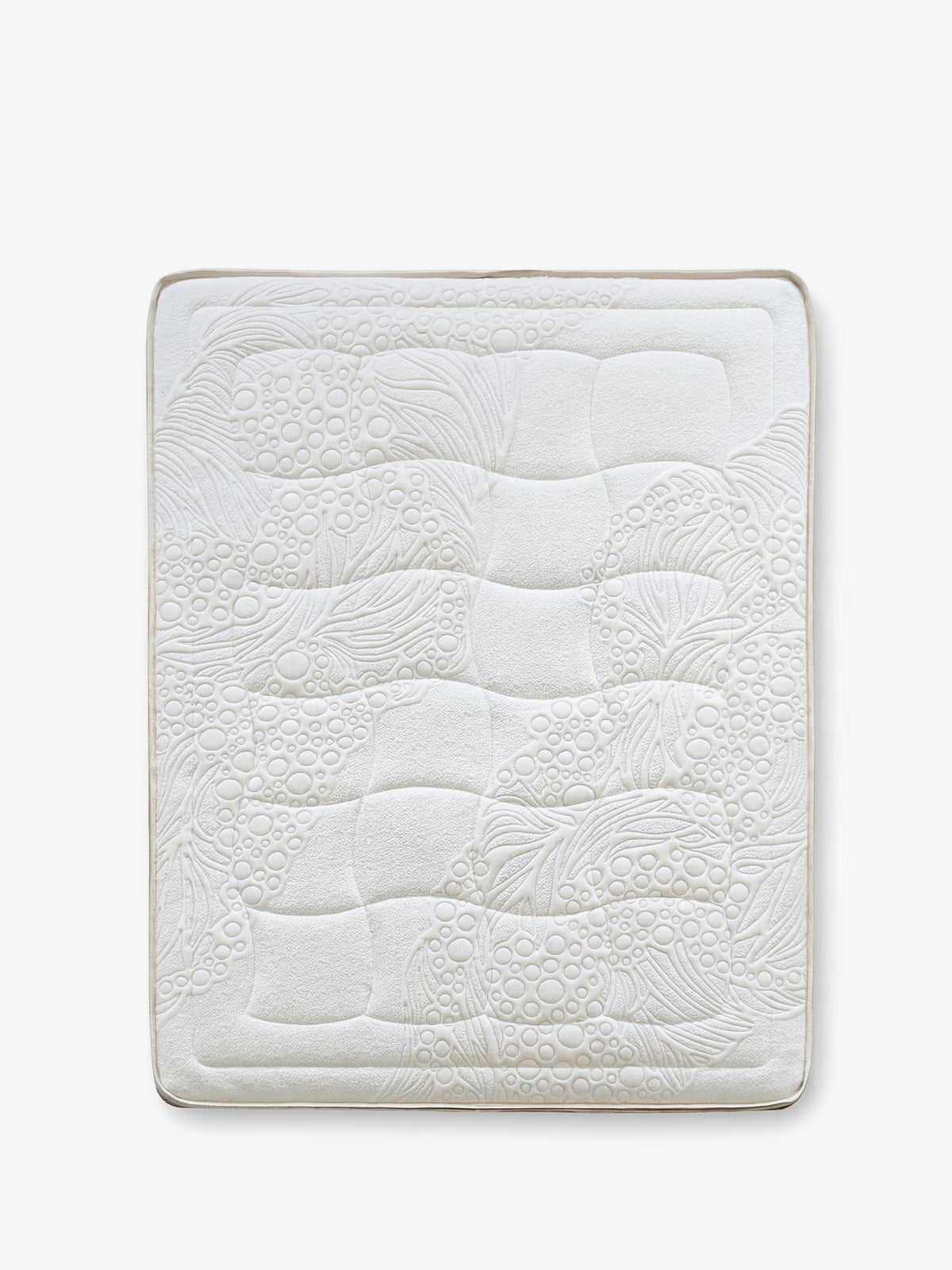 Un coprimaterasso rettangolare bianco di Divani.Store — VELTHA Materasso Bio-Adattivo con molle insacchettate e lattice naturale a 7 zone — presenta un design trapuntato e testurizzato con volute, linee curve e forme circolari. Gli angoli arrotondati e l’aspetto morbido e soffice evocano un comfort lussuoso, che richiama il supporto differenziato a sette zone di alta qualità. Il coprimaterasso si stacca su uno sfondo bianco a tinta unita.
