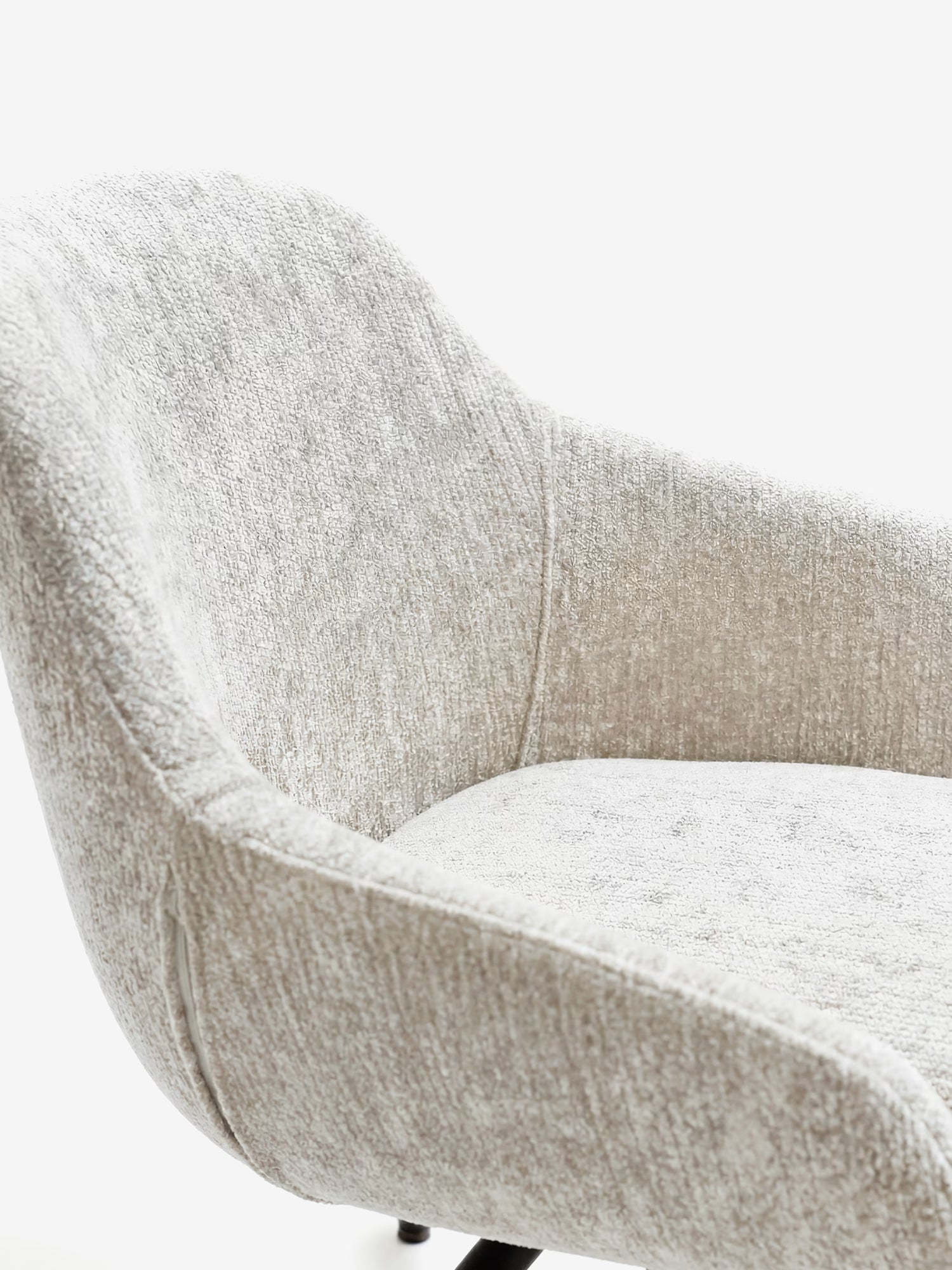 Un primo piano della sedia imbottita Vico di Divani.Store, realizzata in morbido tessuto OEKO-TEX® grigio chiaro e dotata di eleganti gambe in metallo nero. I braccioli ricurvi e lo schienale arrotondato creano un look accogliente e contemporaneo sullo sfondo bianco.