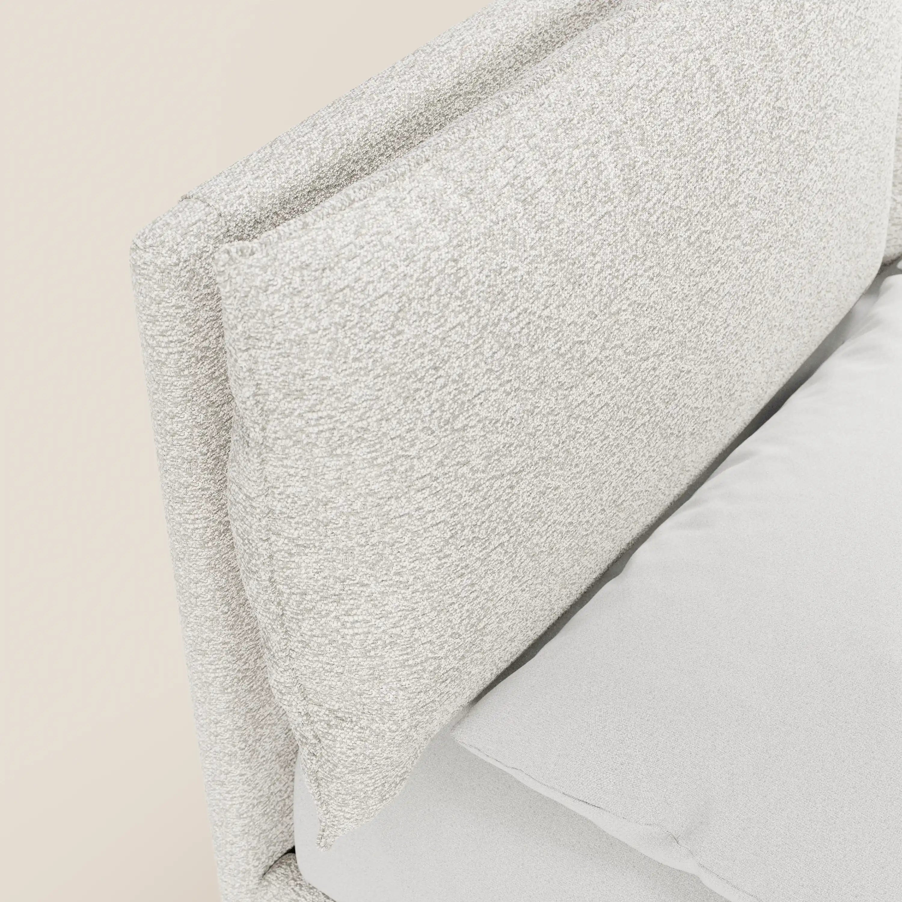 Primo piano di ZAYRON di Letti.store: un moderno letto imbottito con tessuto certificato Oeko-Tex®, cuscini morbidi regolabili e vano contenitore. Nella foto è raffigurato con rivestimento beige chiaro e lenzuolo grigio chiaro, su uno sfondo neutro.