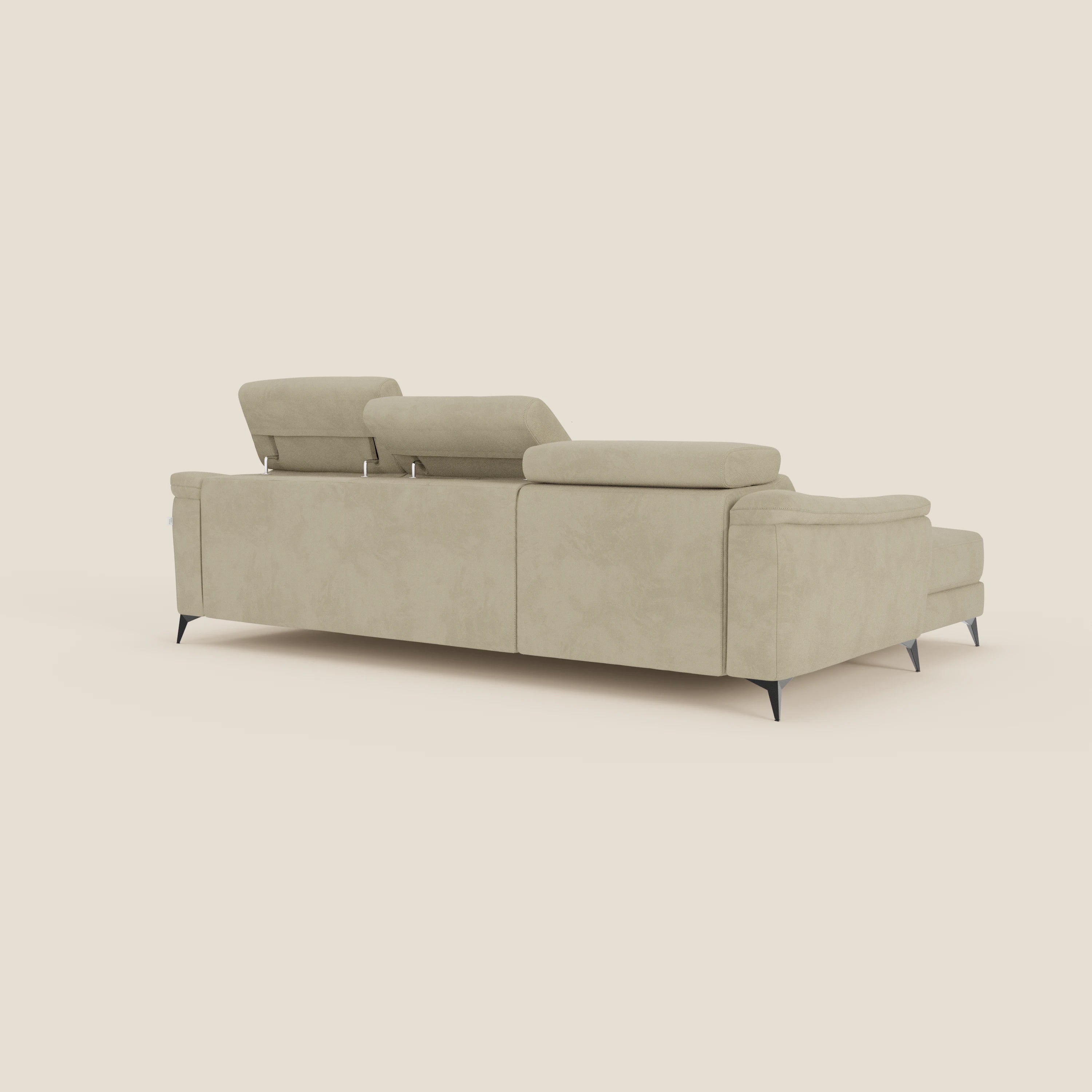 Arcos Divano con penisola di Divani.Store è un moderno divano componibile beige con alte gambe nere, poggiatesta reclinabili e microfibra impermeabile T11. Visto da dietro in posizione angolata, presenta una seduta estraibile e un design minimalista su uno sfondo bianco sporco.