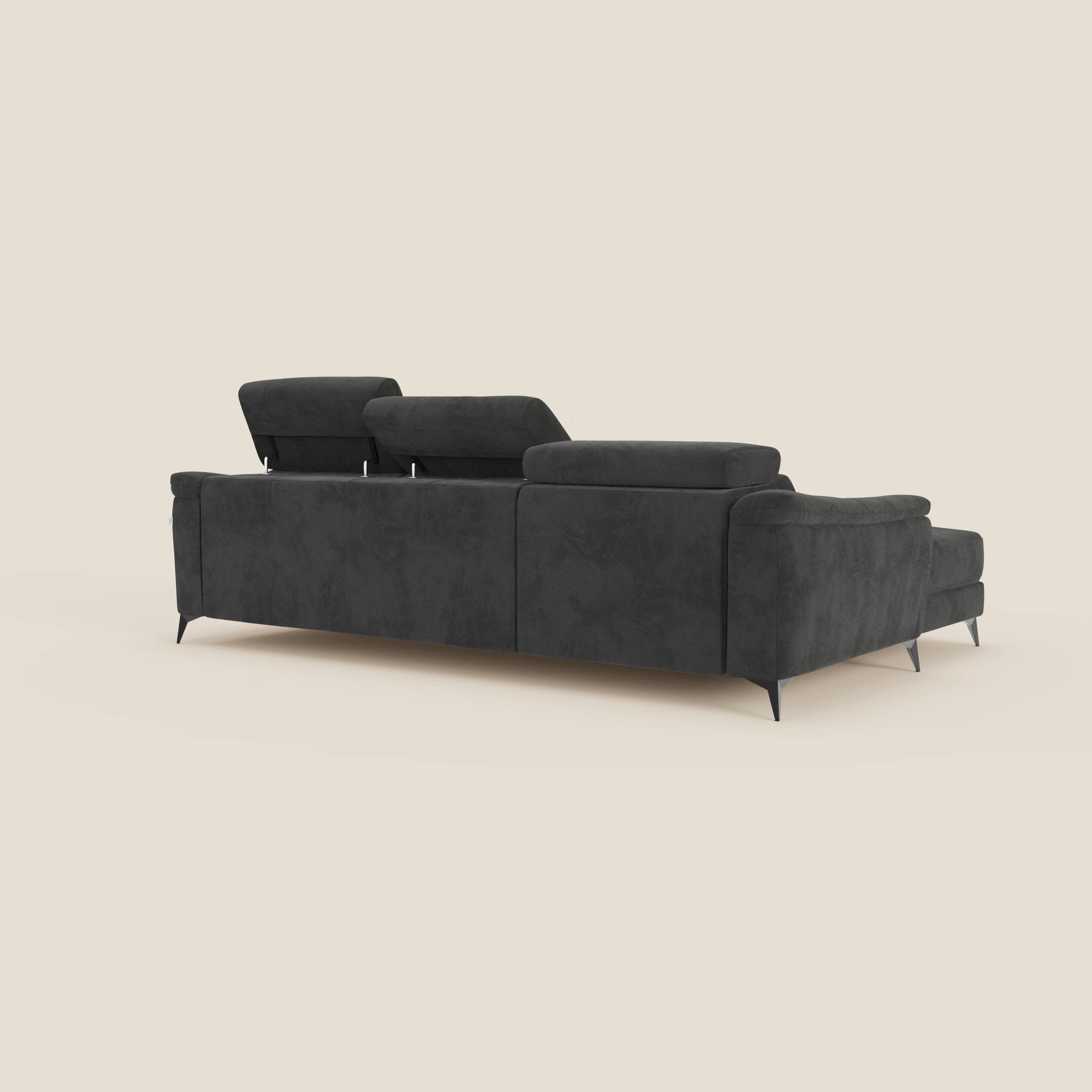 Arcos Divano con penisola di Divani.Store, visto dal retro, è un moderno divano componibile in microfibra nera con poggiatesta regolabile e sottili gambe nere. Le sue linee pulite e la sua imbottitura spiccano su uno sfondo beige chiaro.