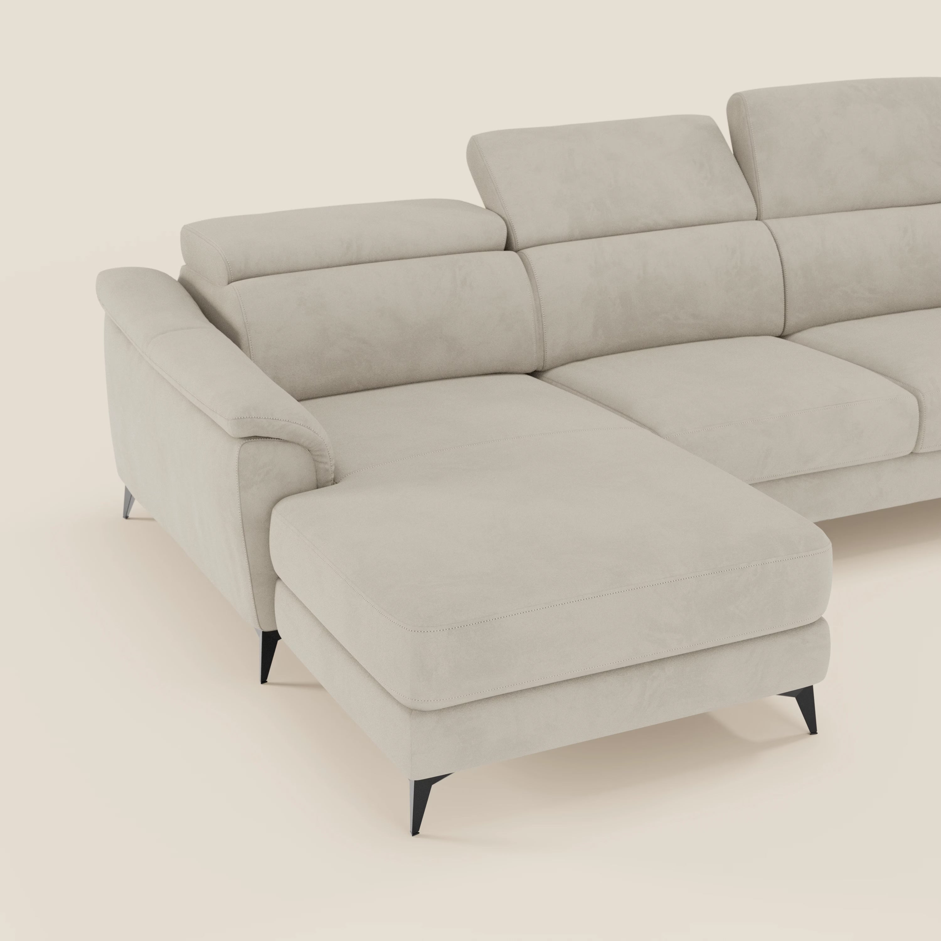 Arcos Divano con penisola di Divani.Store è caratterizzato da gambe alte, poggiatesta regolabili, ampi braccioli e un morbido rivestimento in microfibra impermeabile T11 panna. La chaise longue si estende a sinistra su uno sfondo chiaro.