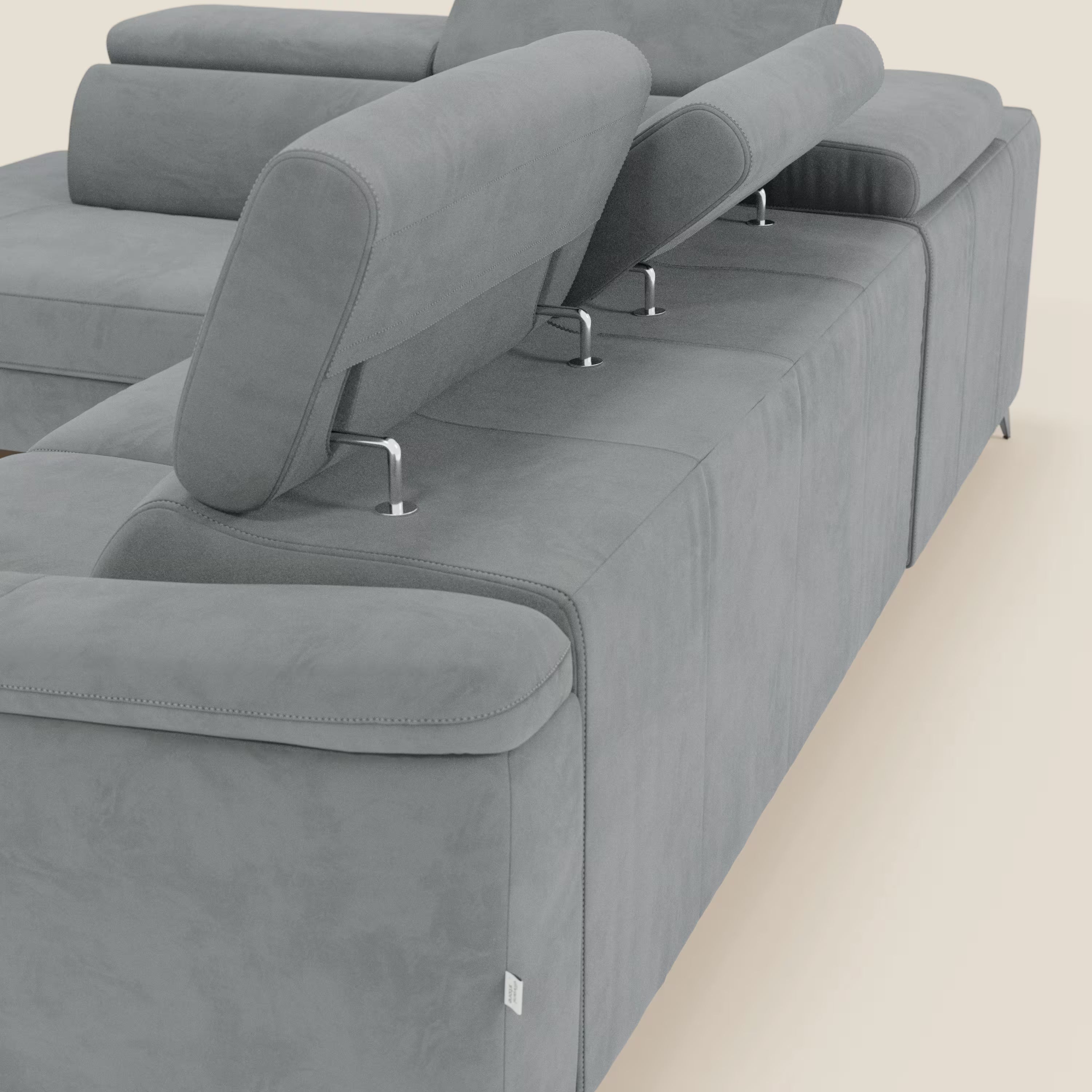 Arcos Divano angolare di Divani.Store è caratterizzato da gambe alte, poggiatesta regolabili e ampi braccioli in microfibra impermeabile grigio T11. Il tessuto liscio, le cuciture pulite e gli eleganti supporti metallici risaltano su uno sfondo luminoso minimale.