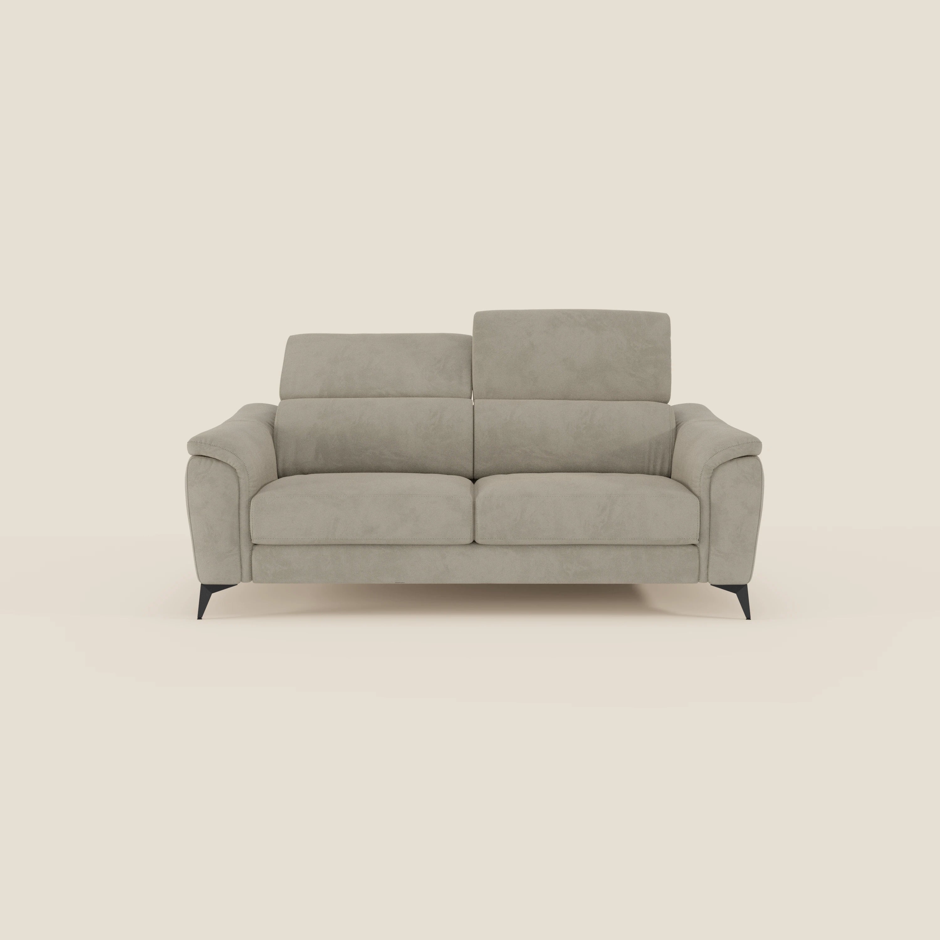 Arcos Divano 3 posti di Divani.Store è caratterizzato da gambe alte e poggiatesta regolabili in microfibra impermeabile T11 taupe, con braccioli delicatamente curvati e cuscini morbidi, su uno sfondo bianco sporco.