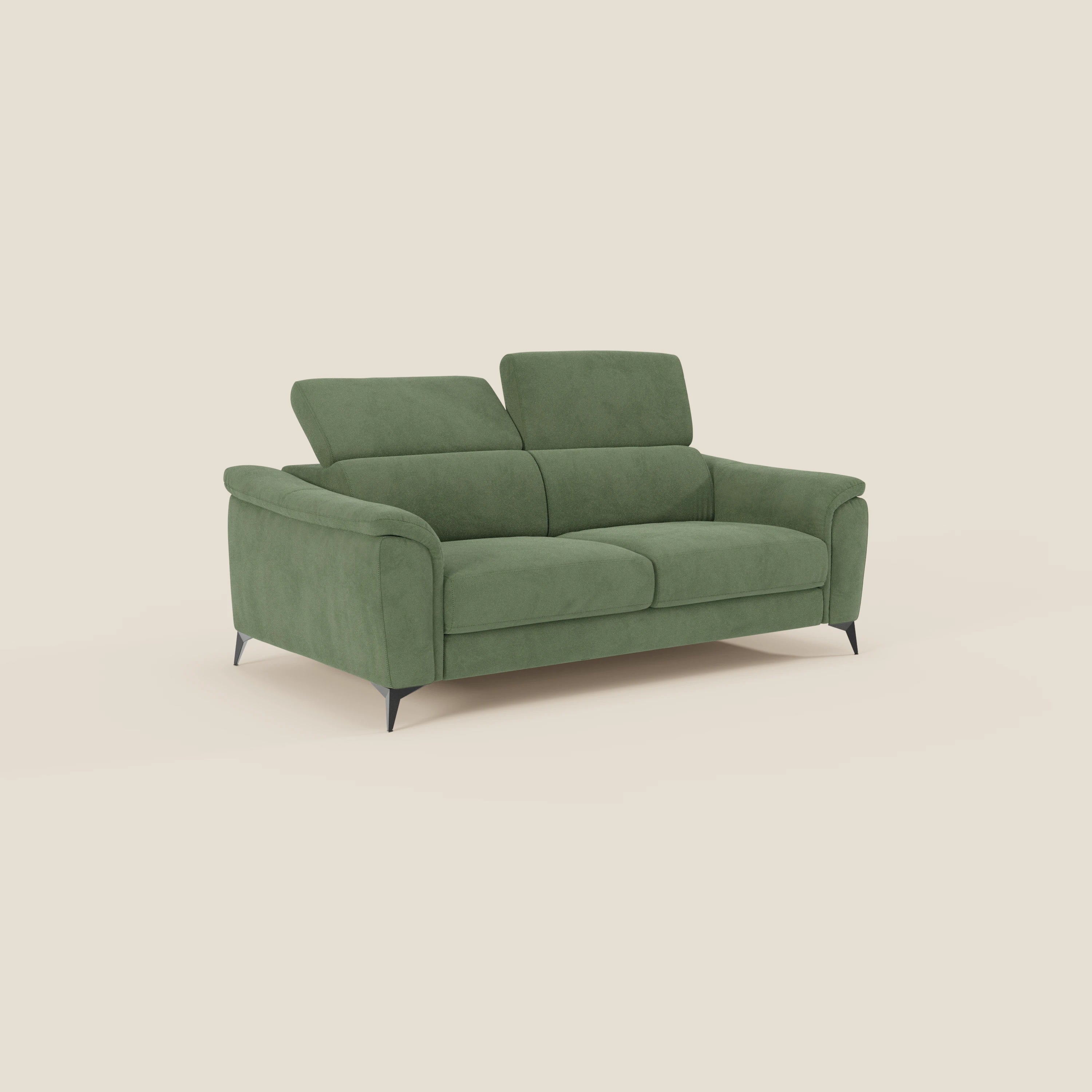 Il Divani.Store Arcos Divano 3 posti in microfibra impermeabile verde T11 ha sedute imbottite, ampi braccioli, gambe nere ad angolo alto e poggiatesta regolabile. Il divano è inserito in uno sfondo bianco sporco.