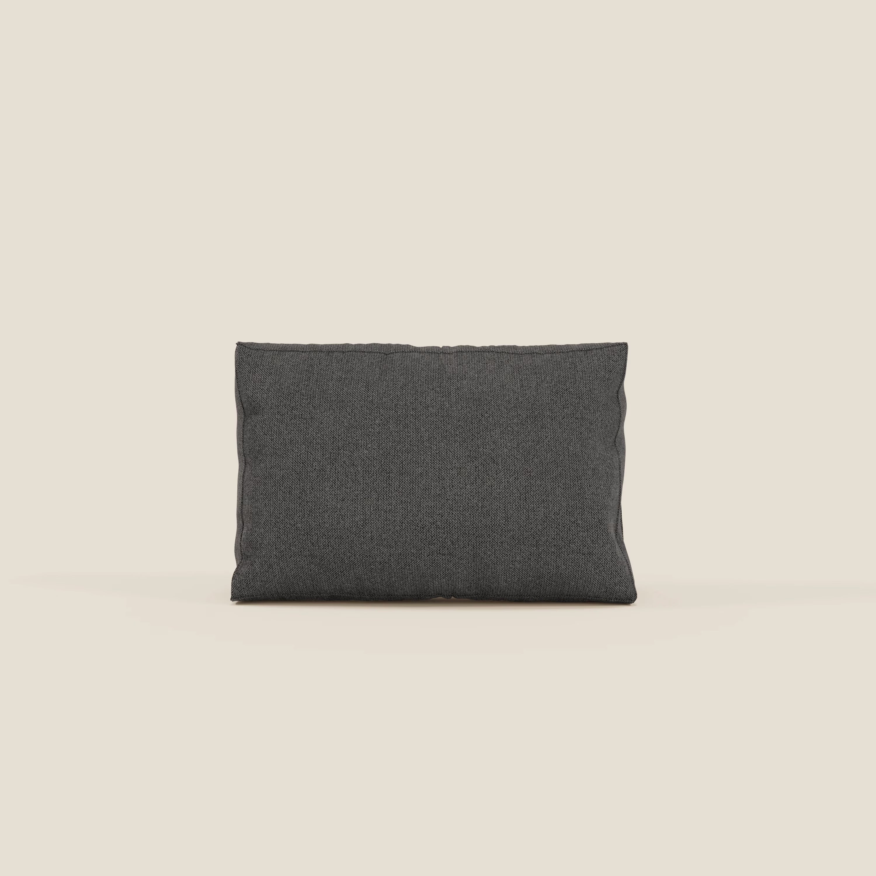 Il cuscino schienale BonBon di Divani.Store, in tessuto smacchiabile T23 antracite, è presentato in piedi su uno sfondo beige chiaro. La sua forma rettangolare e le sottili pieghe esaltano l'ambiente minimalista. Disponibile in 2 misure.