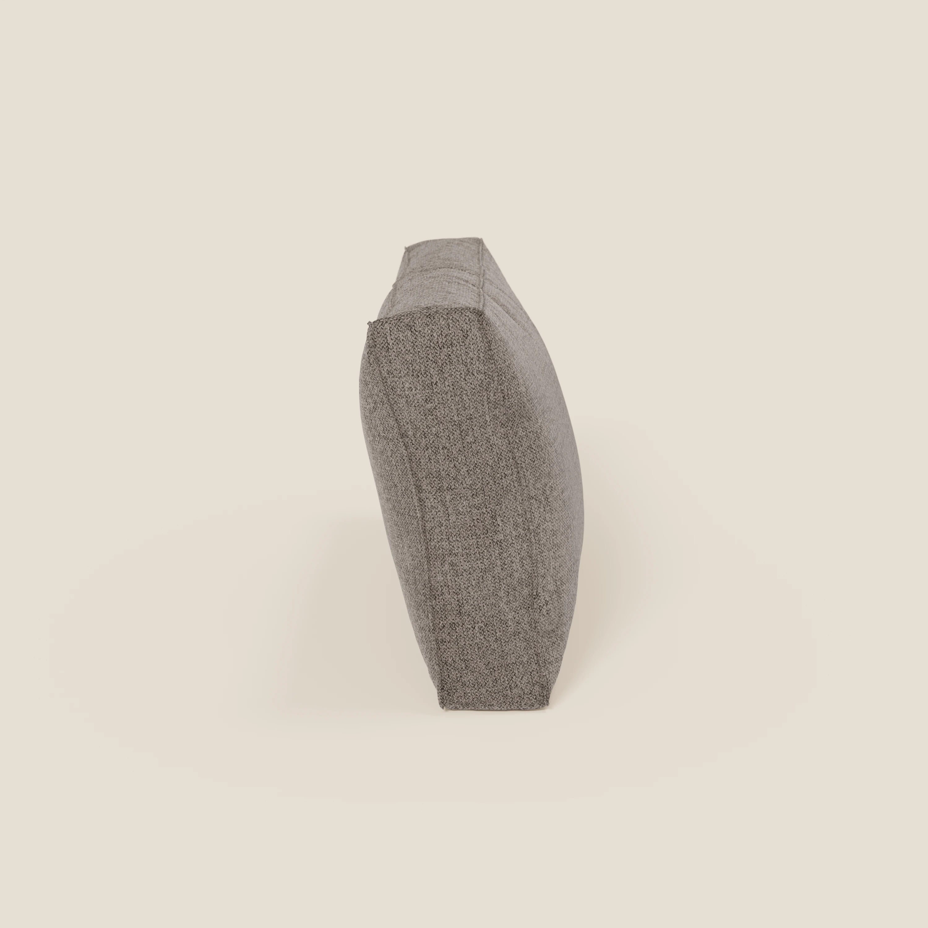 Il cuscino schienale BonBon di Divani.Store, raffigurato in posizione verticale sul bordo lungo in tessuto smacchiabile T23 talpa, presenta una sottile trama e appare spesso e robusto. Disponibile in 2 misure.