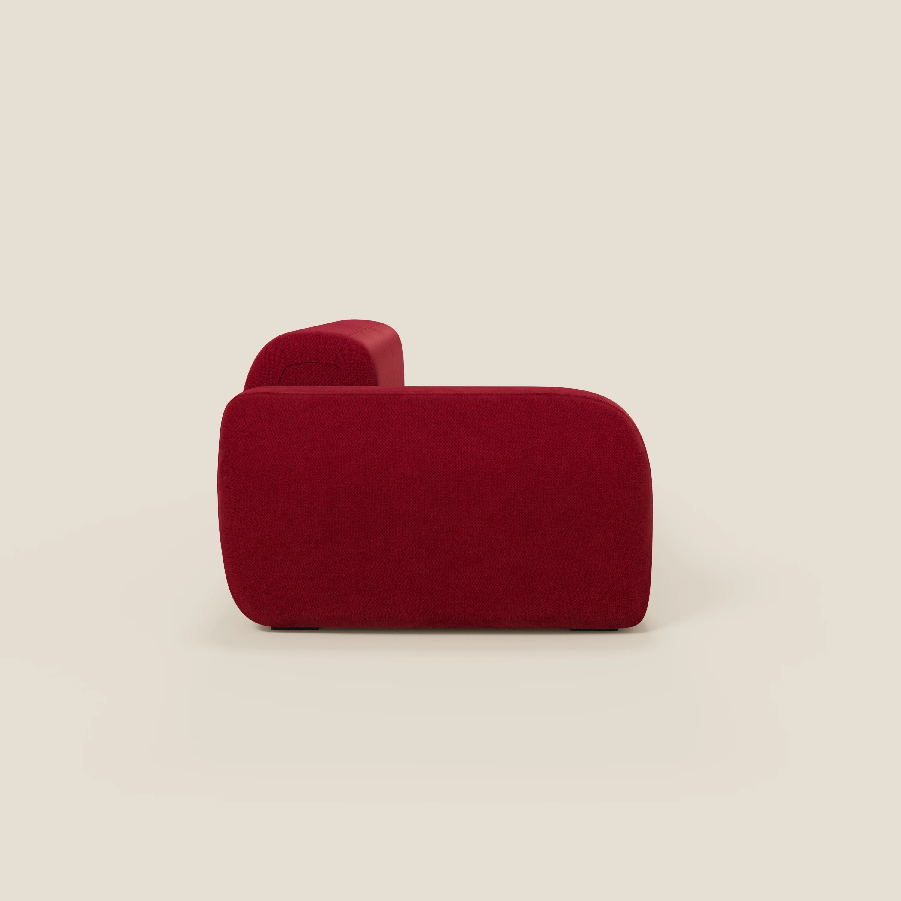 Il BonBon Divano componibile di Divani.Store, visto di lato, presenta una forma rettangolare e voluminosa in tessuto smacchiabile T23 bordeaux con bordi arrotondati e senza gambe visibili, su uno sfondo bianco sporco.