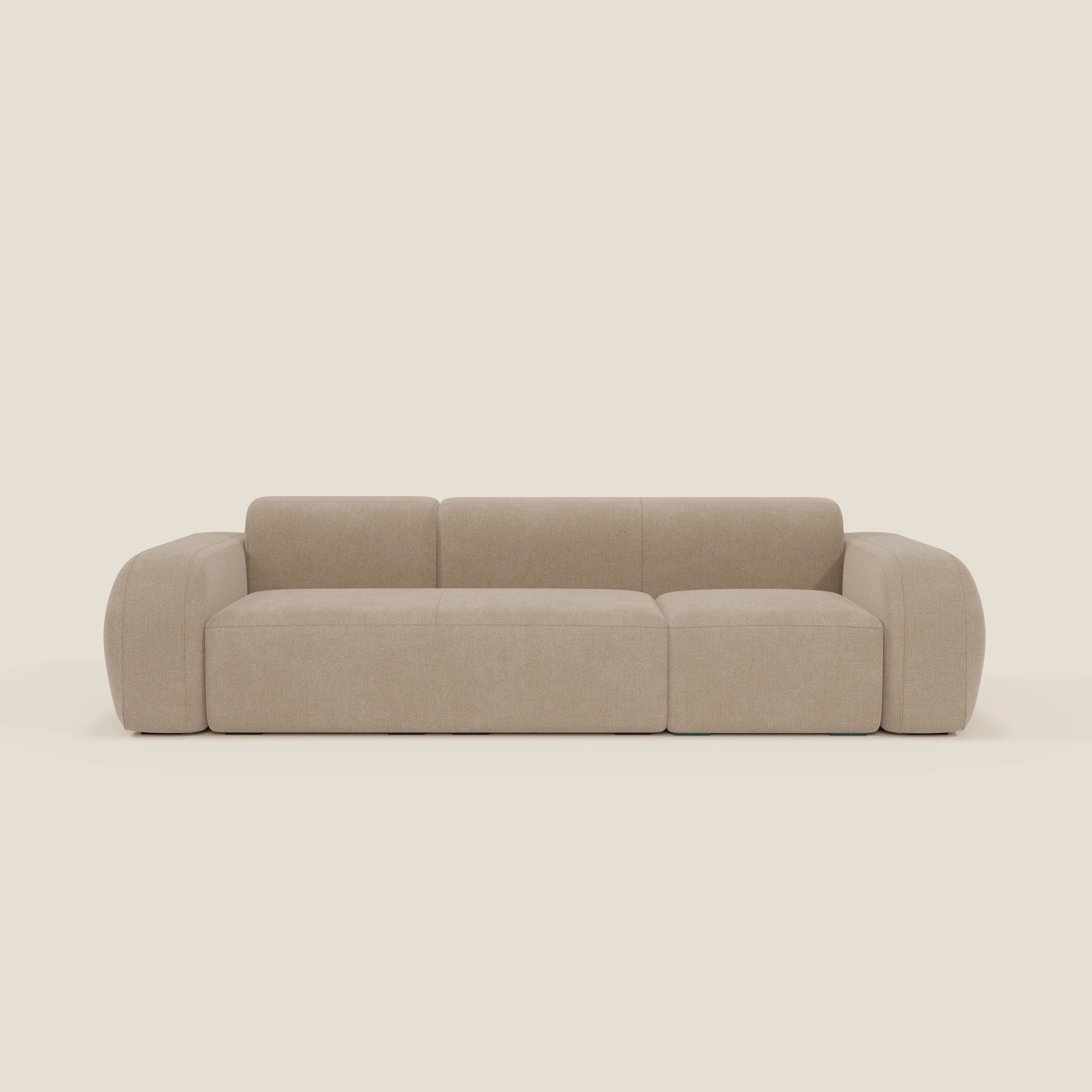 Il BonBon Divano componibile Spaccamattone di Divani.Store in T23 beige è un divano moderno per tre persone, caratterizzato da braccioli larghi e arrotondati, schienale basso, bordi morbidi e sedute in peluche, il tutto su uno sfondo bianco sporco.