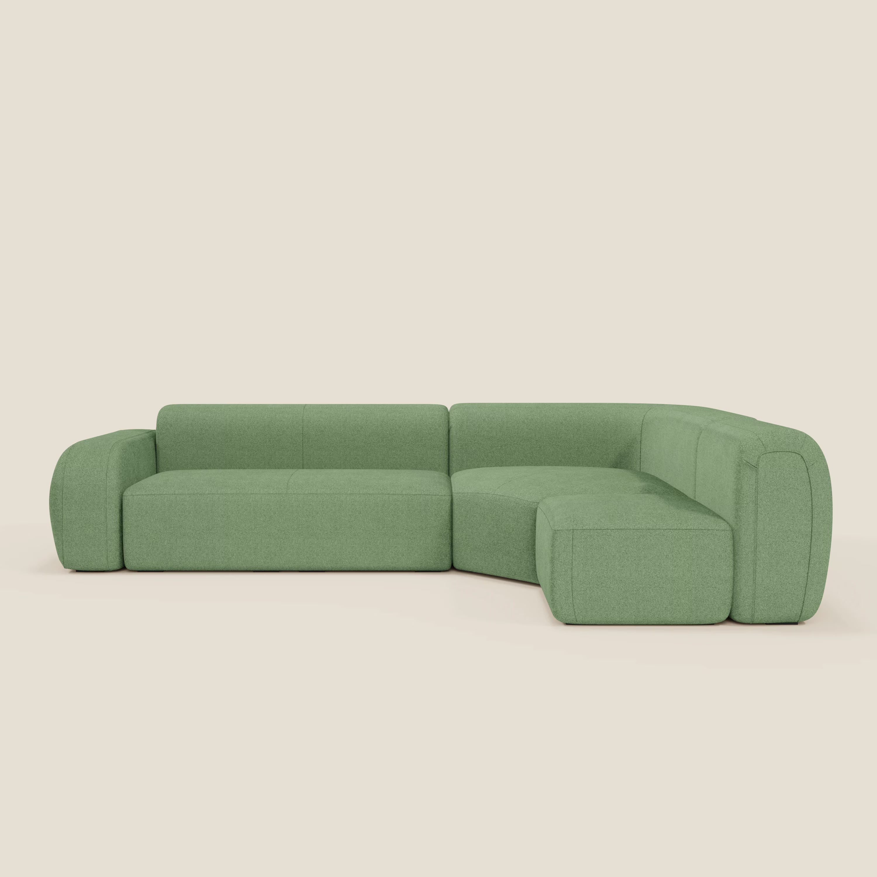 Il divano BonBon angolare componibile e modulare di Divani.Store è rivestito in tessuto smacchiabile T23 menta, con braccioli e schienali arrotondati, ampie sedute imbottite, profilo basso e sfondo bianco sporco.