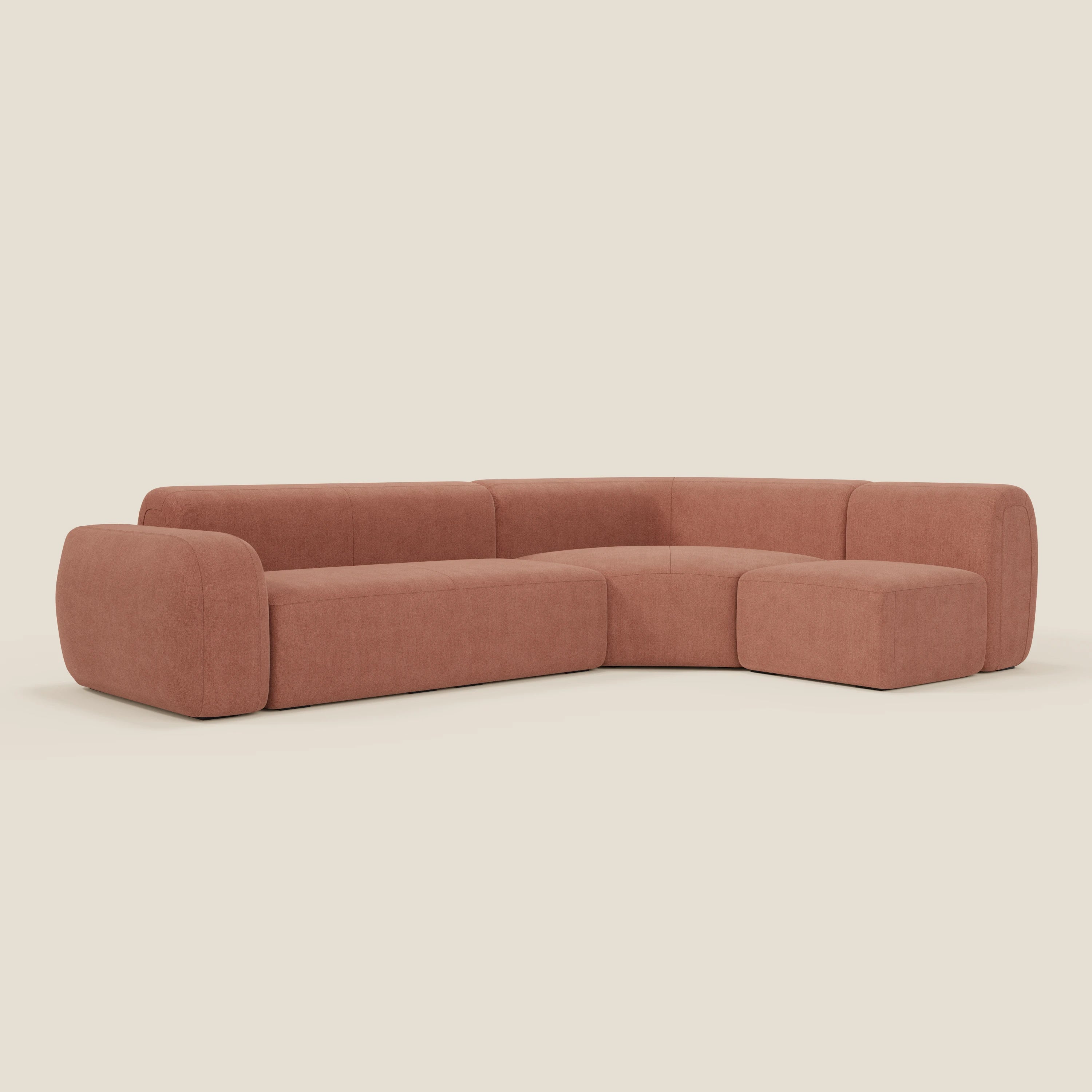 Il divano angolare componibile e modulare BonBon di Divani.Store, in tessuto smacchiabile T23 pesca, presenta un design moderno a forma di L con braccioli arrotondati e cuscini morbidi, offrendo un'estetica morbida e minimalista.