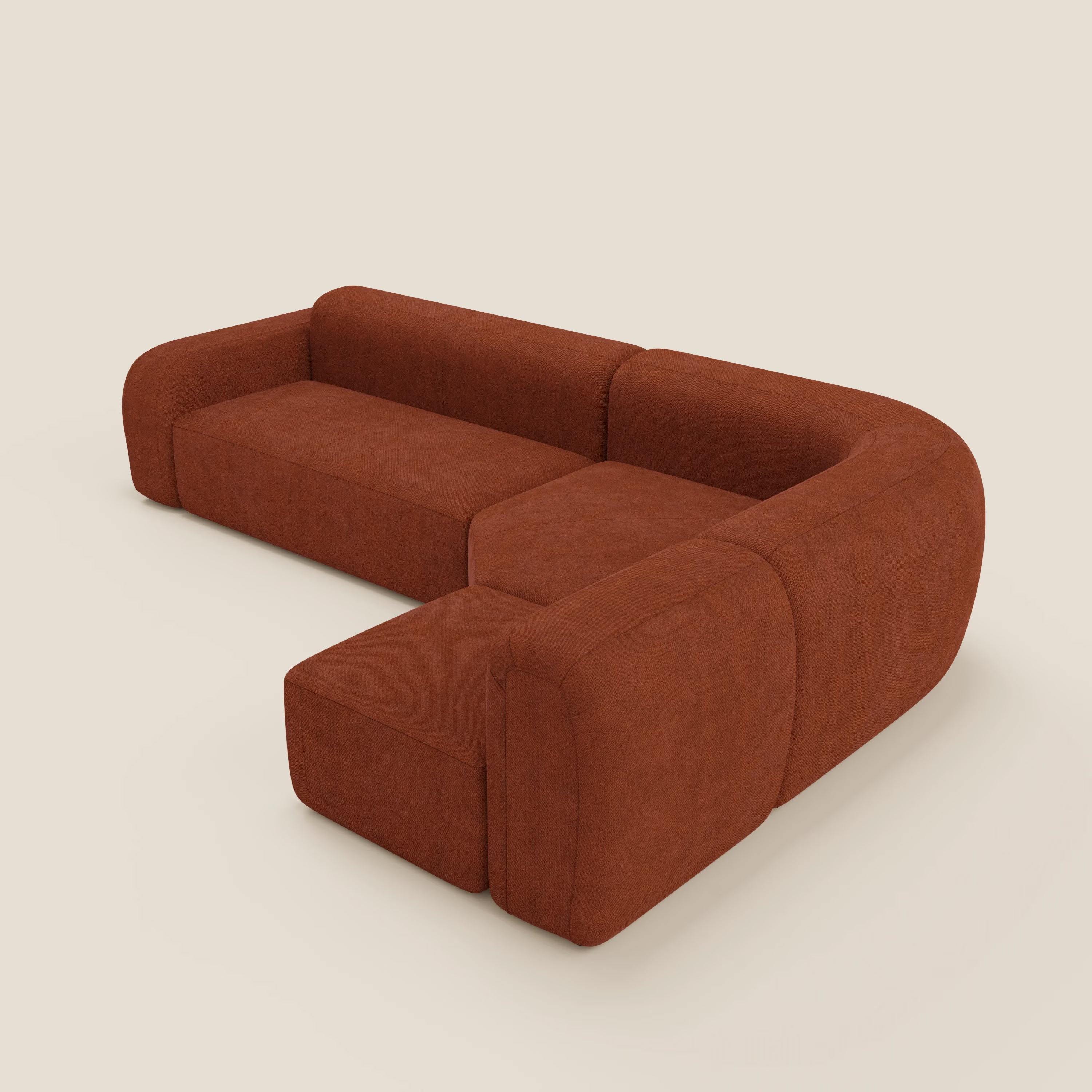 Il divano angolare componibile e modulare BonBon di Divani.Store, in tessuto T23 ruggine facile da pulire, presenta linee pulite, cuscini morbidi e bordi arrotondati per un look moderno e invitante su uno sfondo beige chiaro.