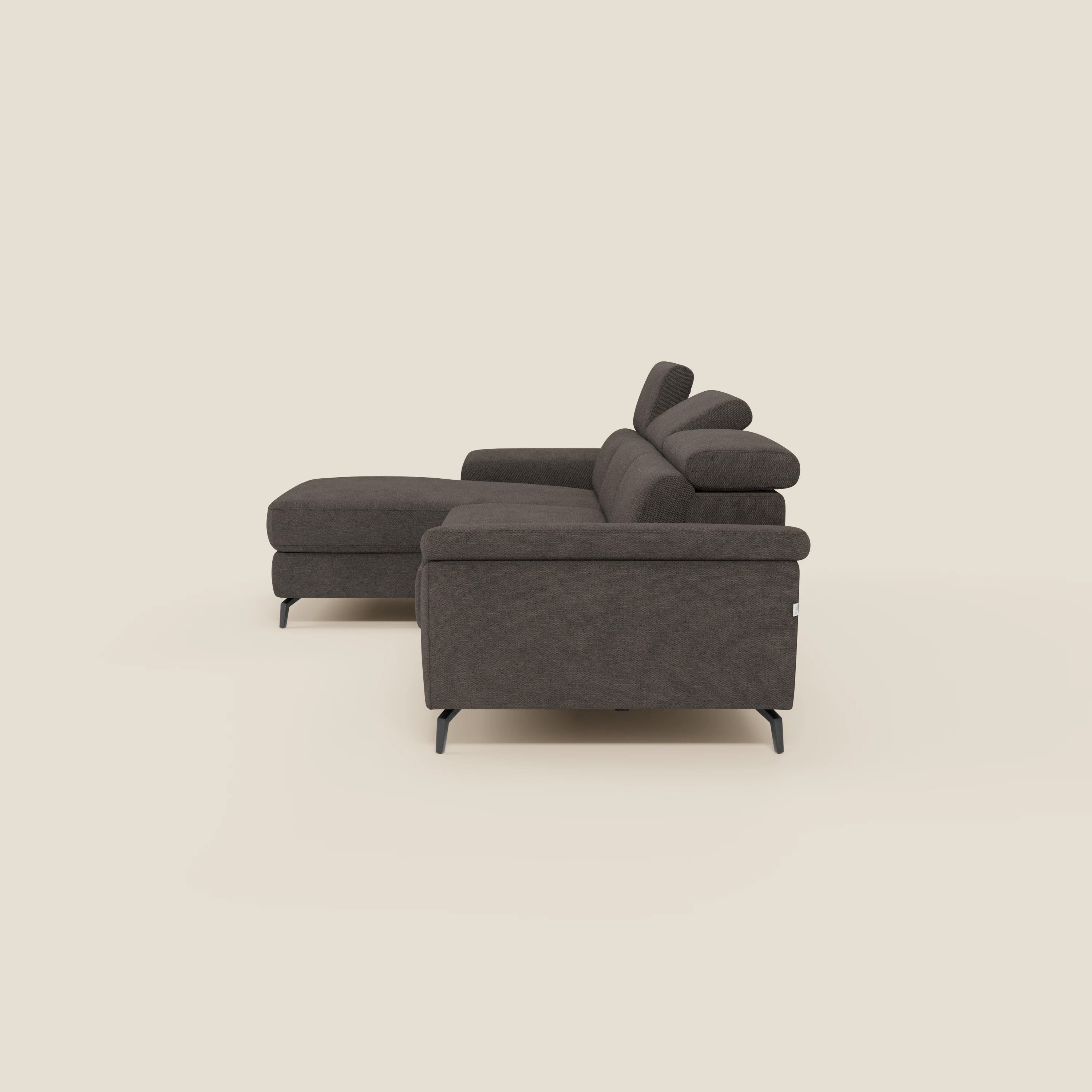 Il divano estraibile Estro di Divani.Store, in tessuto impermeabile marrone T14, è dotato di chaise-longue e poggiatesta regolabili. Presentato nella versione orientata a sinistra, con linee moderne e dettagli minimali, è dotato di eleganti gambe in metallo nero su sfondo beige.