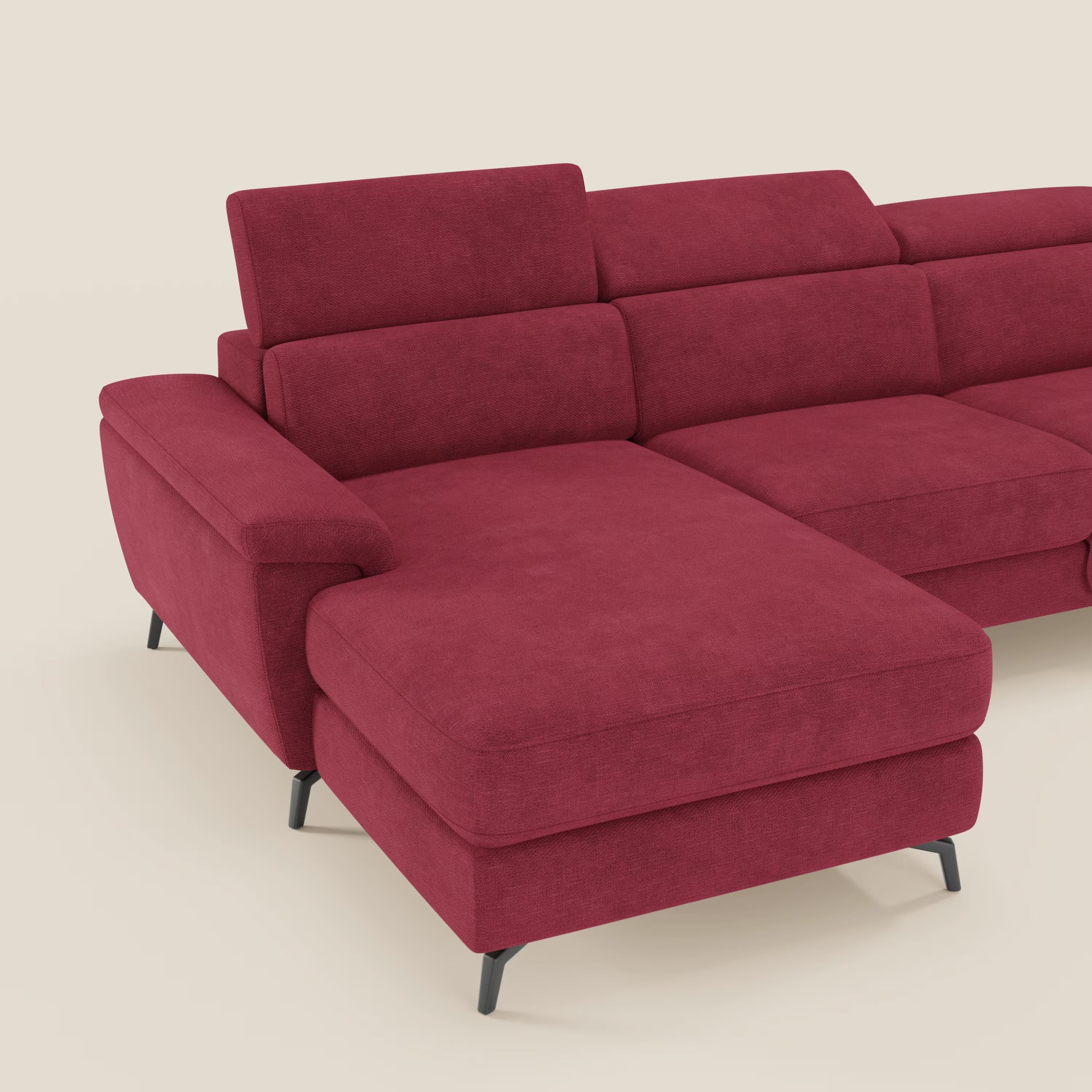 Il divano Estro estraibile di Divani.Store è caratterizzato da una chaise-longue a sinistra, poggiatesta reclinabili, cuscini in feltro e gambe in metallo nero, il tutto in tessuto impermeabile rosso T14. In foto, su uno sfondo bianco sporco.