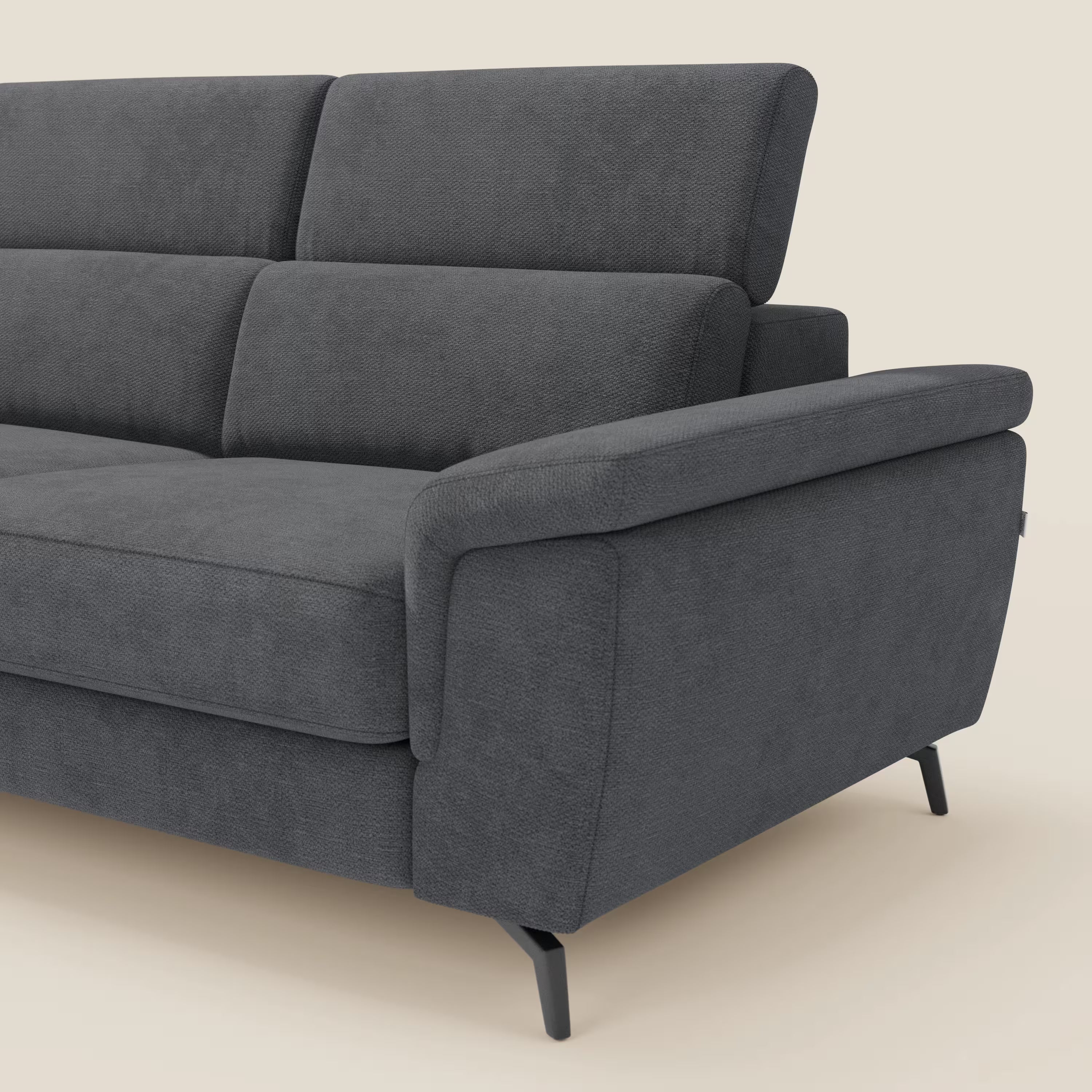 Il divano angolare estraibile Estro Divano di Divani.Store è caratterizzato da poggiatesta reclinabili, tessuto impermeabile T14 antracite, gambe angolari in metallo nero, cuscini spessi, schienale alto e ampi braccioli imbottiti; parzialmente raffigurato su sfondo beige.