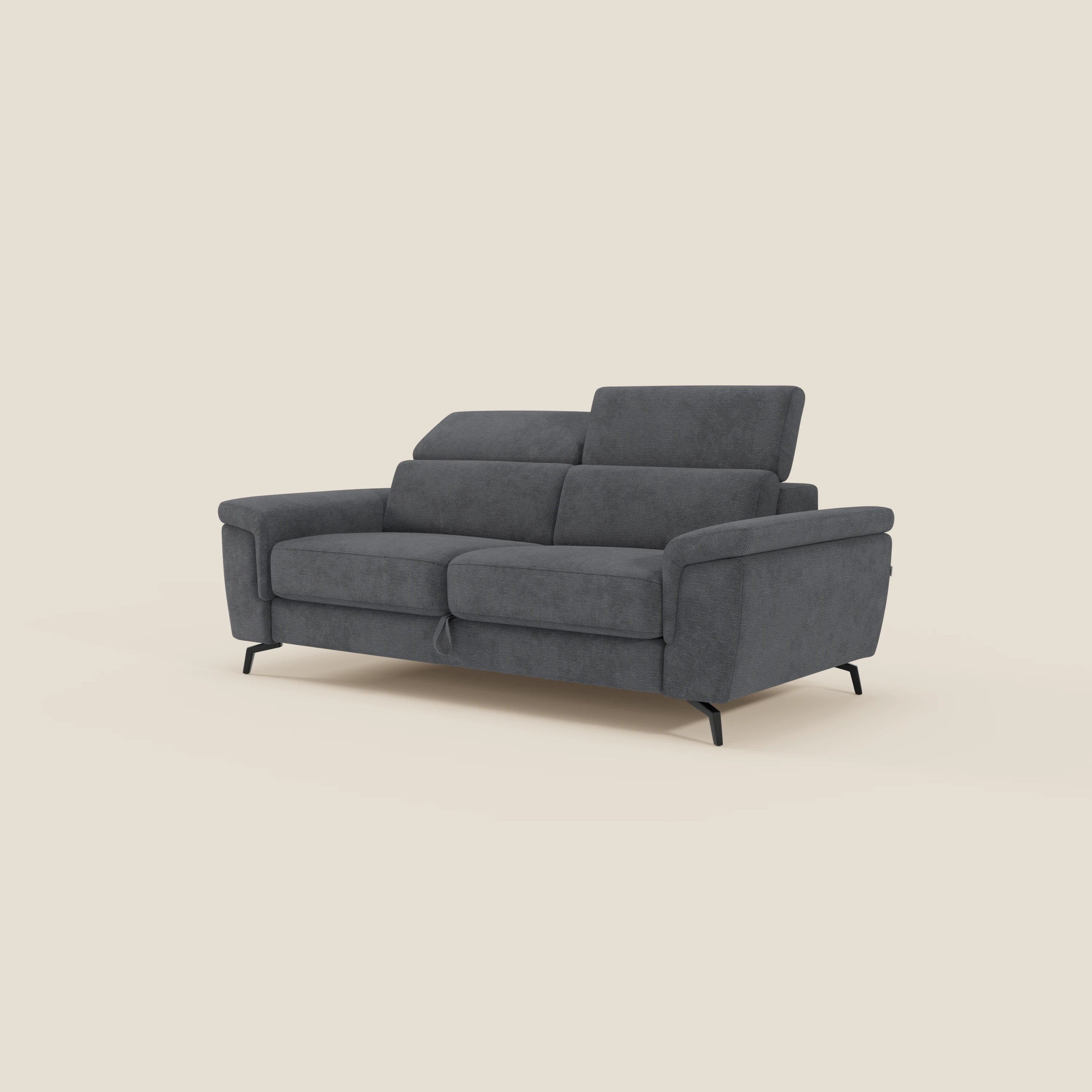 Estro Divano 3 posti con pouf estraibile di Divani.Store è dotato di poggiatesta regolabili, tessuto impermeabile T14 antracite e design moderno con gambe sottili nere, su uno sfondo beige chiaro per un look contemporaneo.