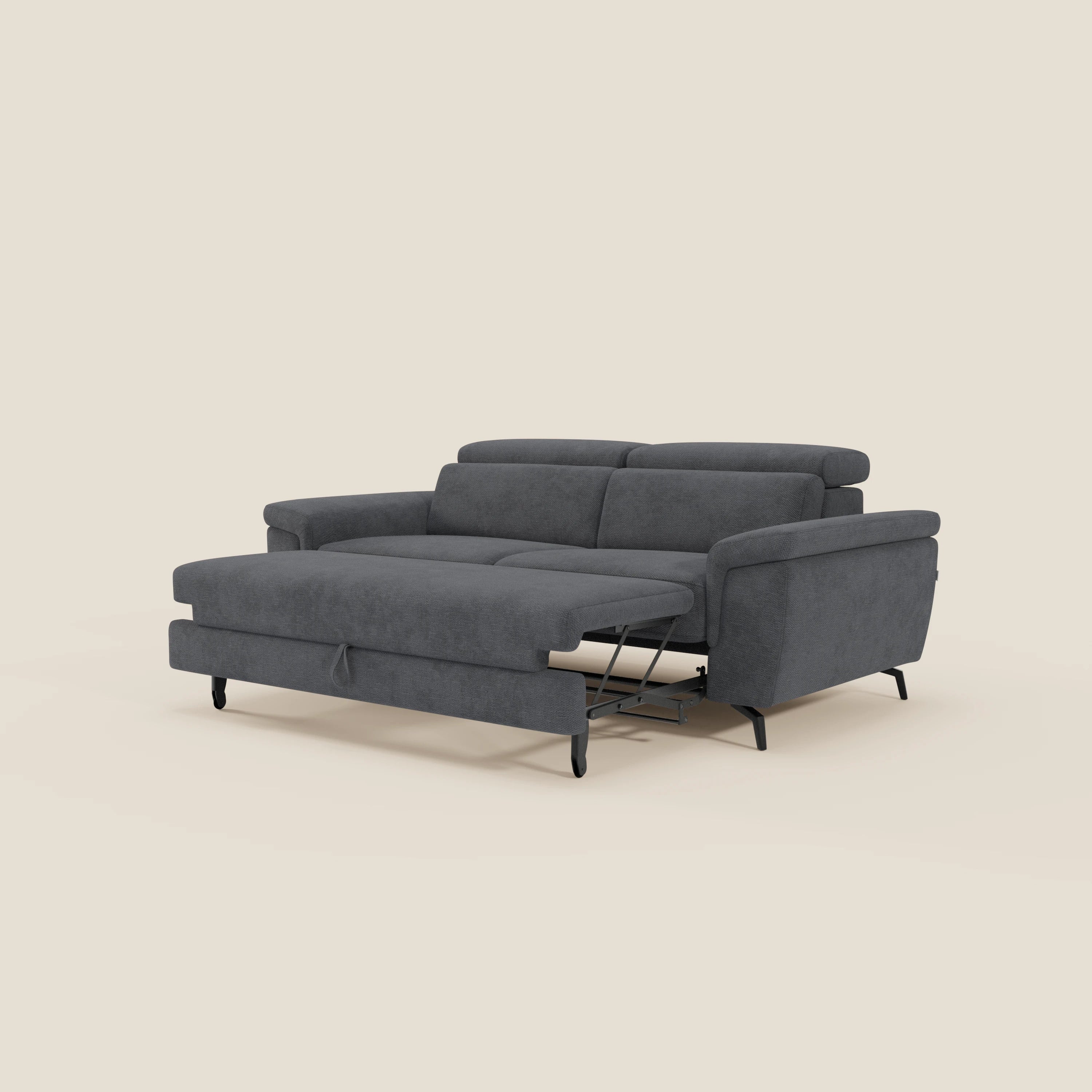 Il divano Estro 3 posti di Divani.Store, in tessuto impermeabile T14 antracite con poggiatesta reclinabili e pouf estraibile, ha ampi braccioli, struttura in metallo e sottili gambe nere su sfondo beige.