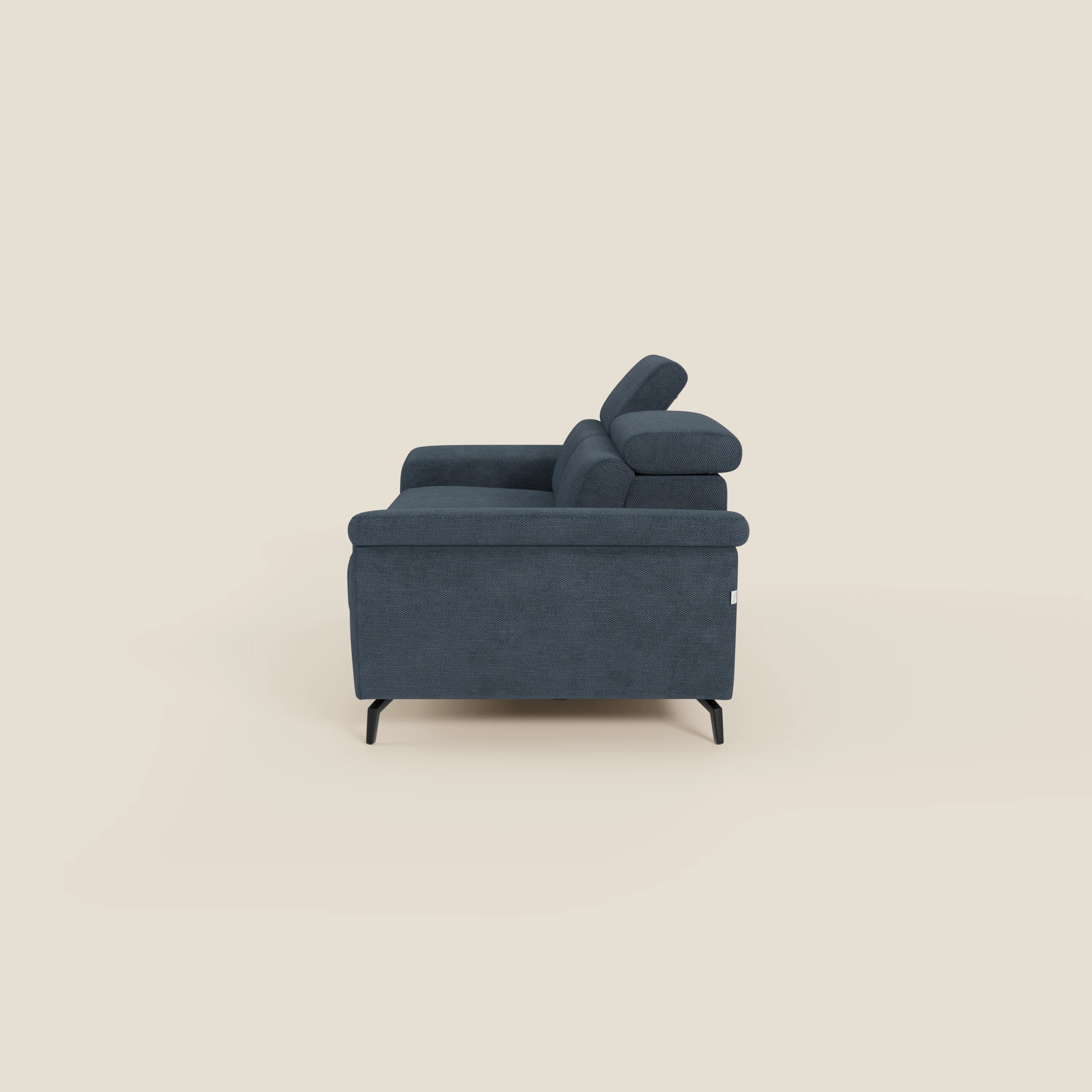 Estro Divano 3 posti con pouf estraibile di Divani.Store è presentato in tessuto T14 blu impermeabile, con gambe sottili nere, ampi braccioli e poggiatesta regolabili, su uno sfondo beige chiaro per un look elegante e contemporaneo.