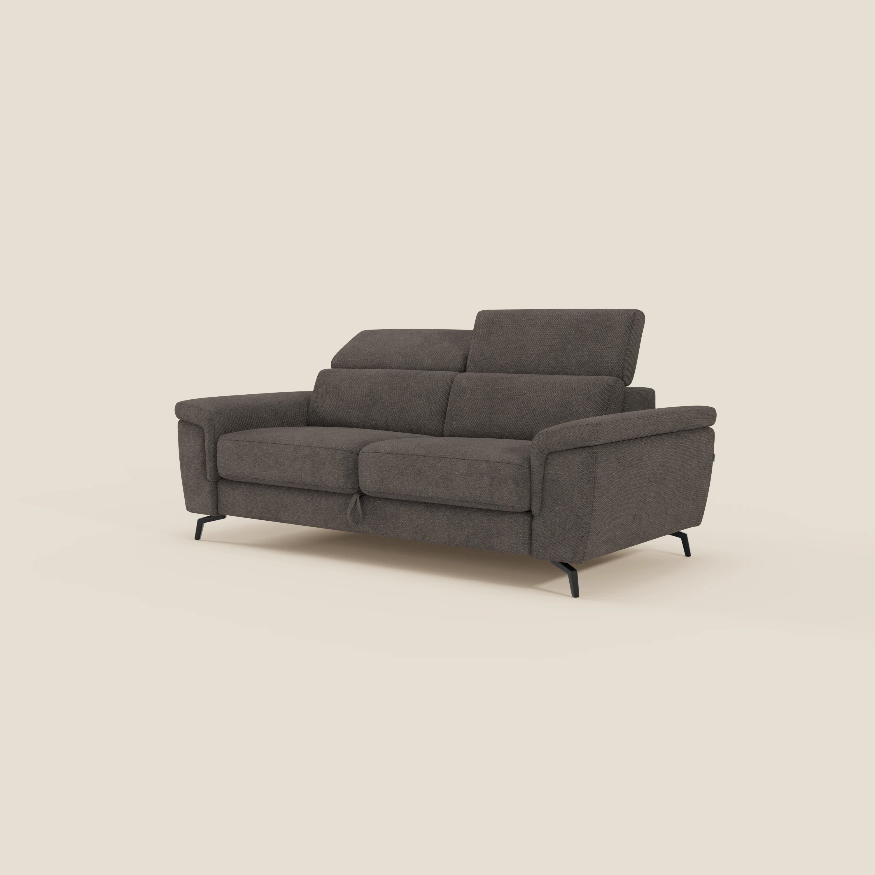 Estro Divano 3 posti di Divani.Store è un moderno divano in tessuto impermeabile marrone scuro con pouf estraibile, poggiatesta reclinabili e sottili gambe in metallo nero, su uno sfondo beige chiaro.
