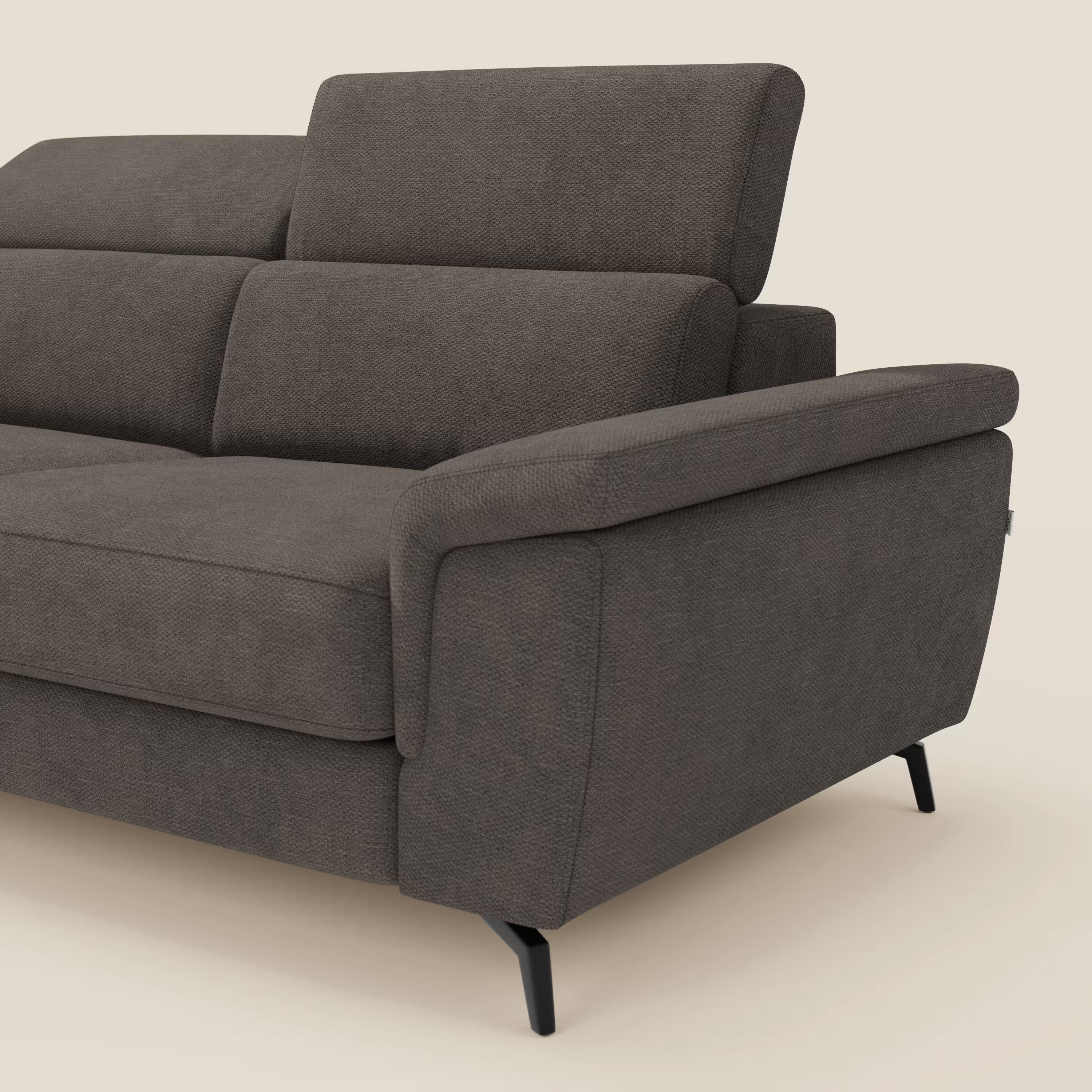 L'Estro Divano 3 posti con pouf estraibile di Divani.Store, in impermeabile T14 marrone, vanta poggiatesta reclinabili, braccioli imbottiti e gambe angolate in metallo nero. Il design pulito e squadrato è caratterizzato da una texture visibile, su sfondo beige.